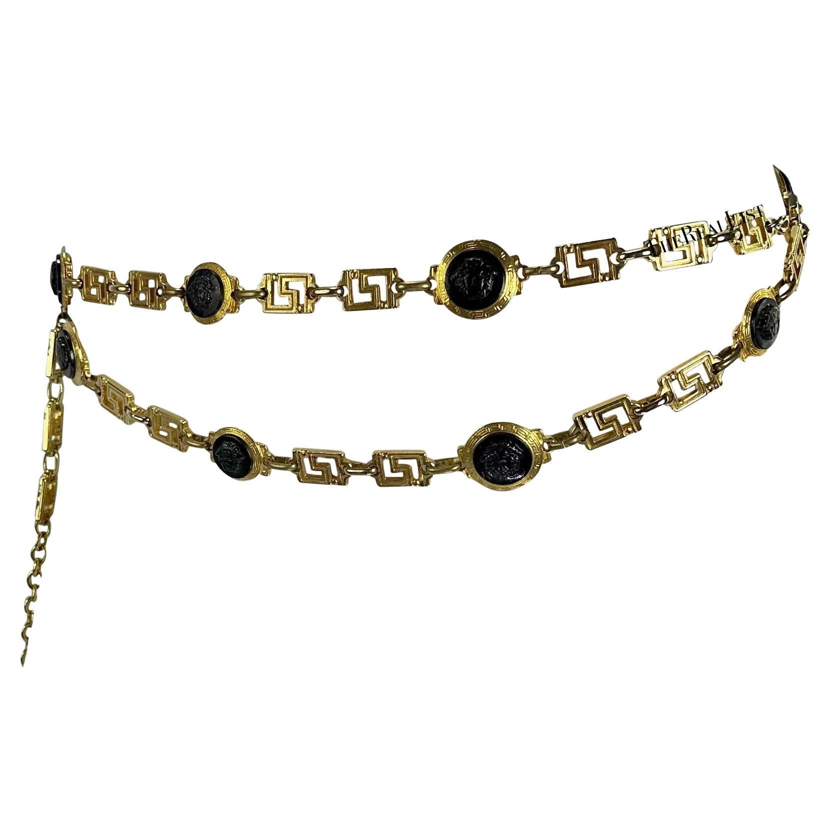 Presenting a beautiful gold-tone Gianni Versace chain link belt, designed by Gianni Versace. From the 1990s, this incredible belt features a Greek key link broken up black Versace Medusa reliefs with a double layer chain at the front, this chic belt
