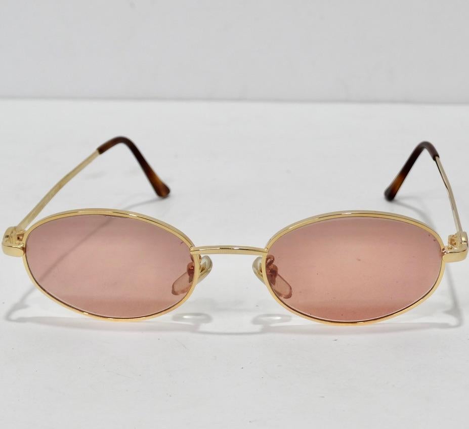 Ces lunettes de soleil de Versace, datant des années 1990, sont vraiment superbes ! Parfaites pour celles qui aiment les montures circulaires, ces lunettes présentent des verres roses poussiéreux et des détails dorés. Ce sont les lunettes de soleil