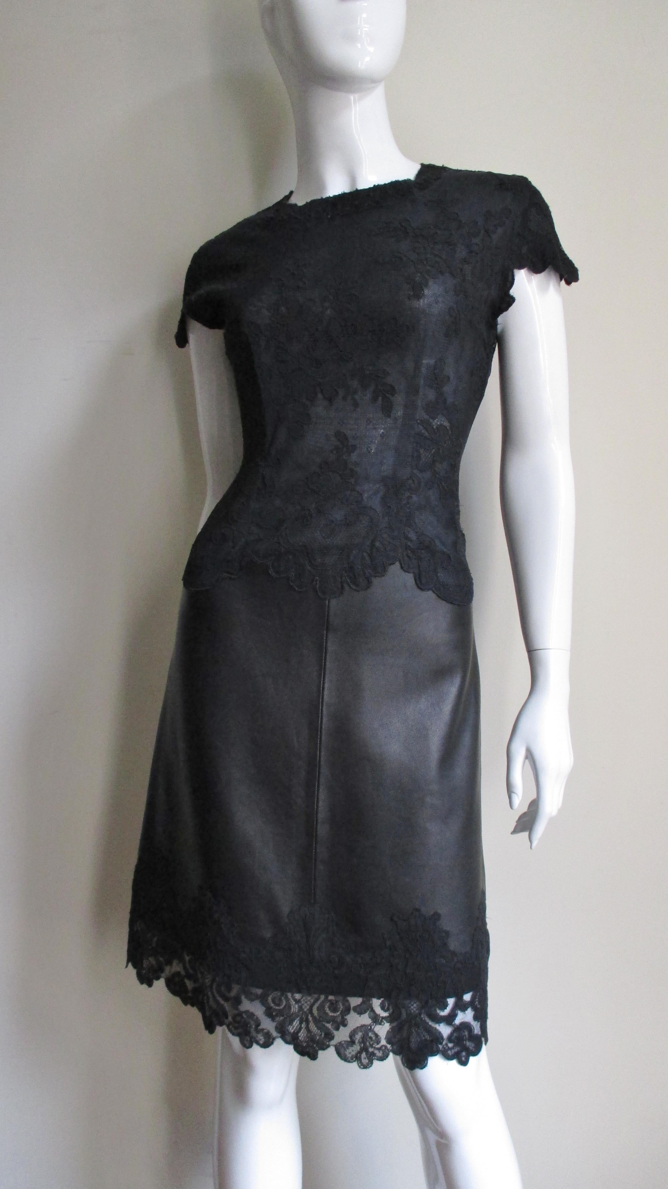 A fabulous black leather and lace dress by Gianni Versace.  It has flower pattern lace cap sleeve semi fitted bodice and around the hem.  The leather skirt portion has a subtle A line. The dress closes in the back with an invisible zipper and is