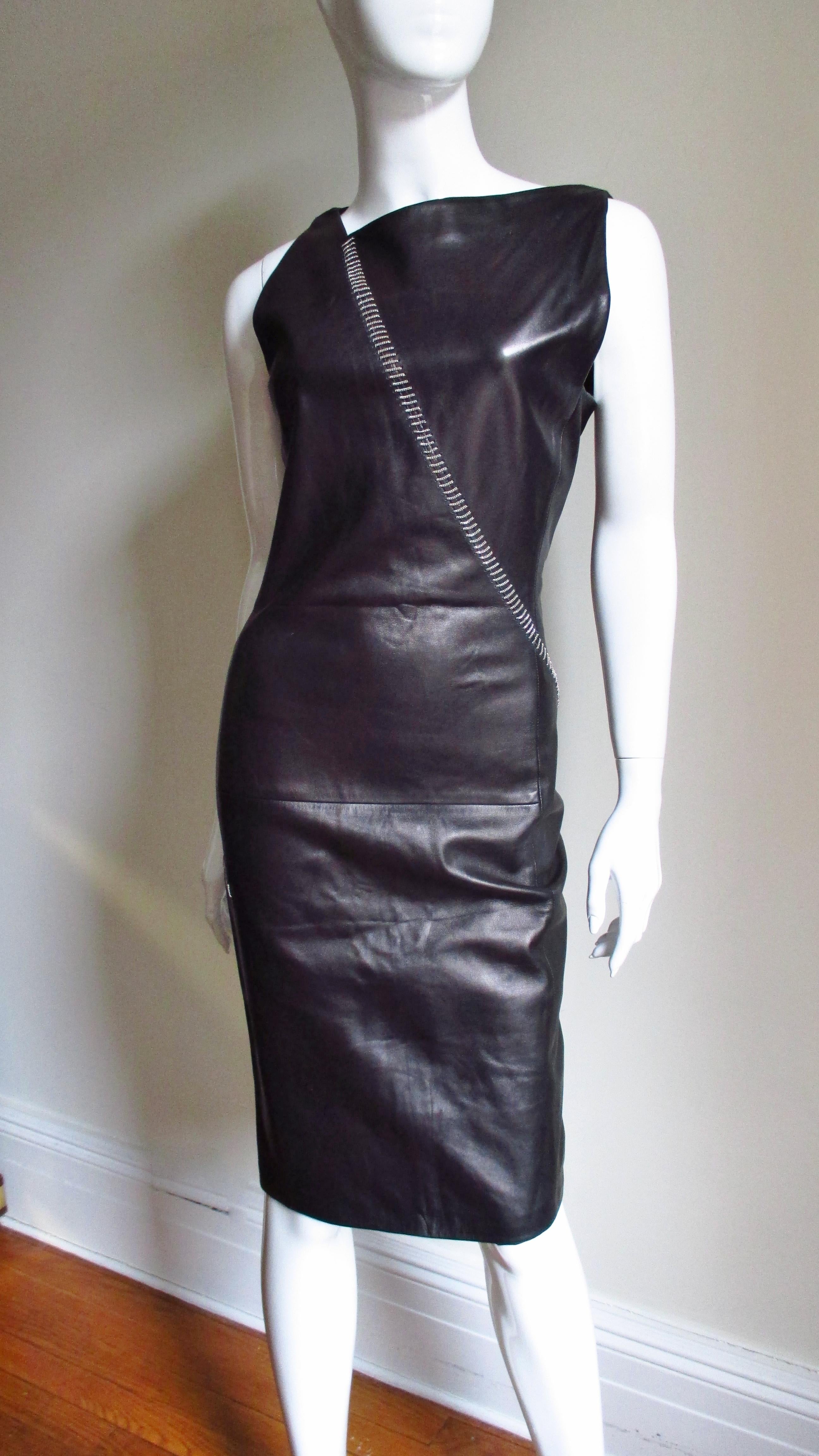 A fabulous soft supple black leather dress from Gianni Versace.  It is semi fitted with an asymmetrical neckline and intricate horizontal rows of fine silver chain forming a line starting at one shoulder crossing the front diagonally to the hip then