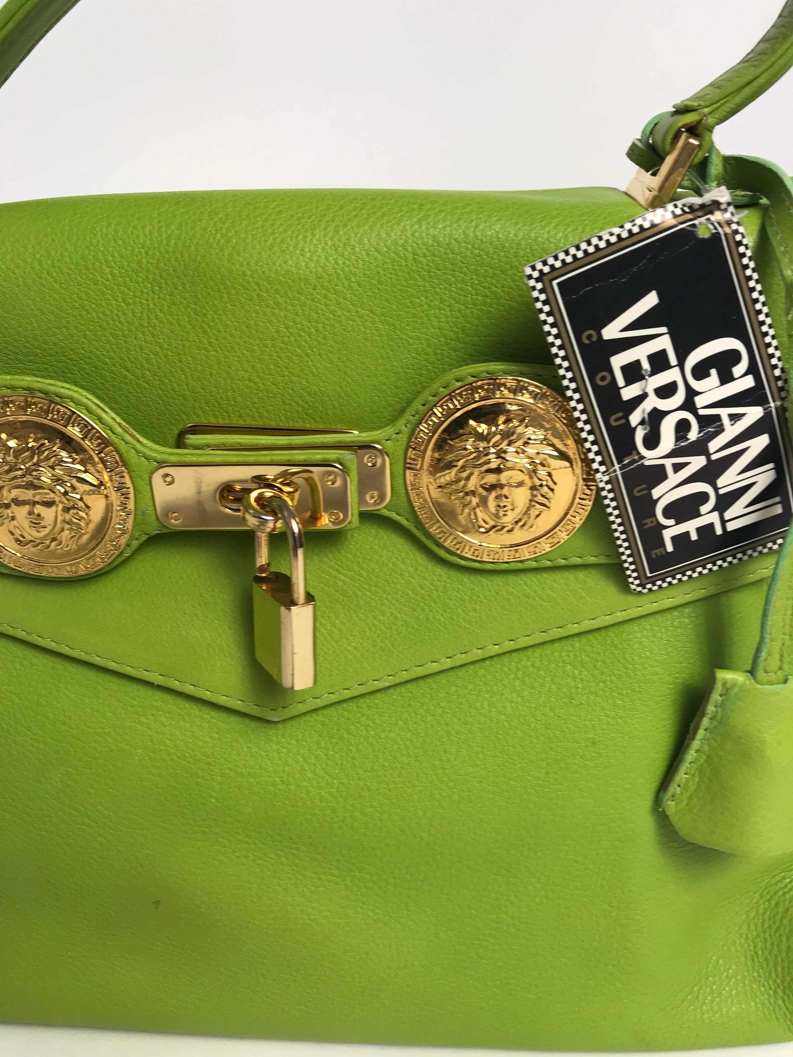 1990s Lime green leather Gianni Versace Kelly bag with gold-tone hardware, top handle and shoulder strap. Medusa embellished belted accents. Lock and key. Includes tag. Condition: very good, small spot on front, see photos. 
12” W x 9” H x 4” D.