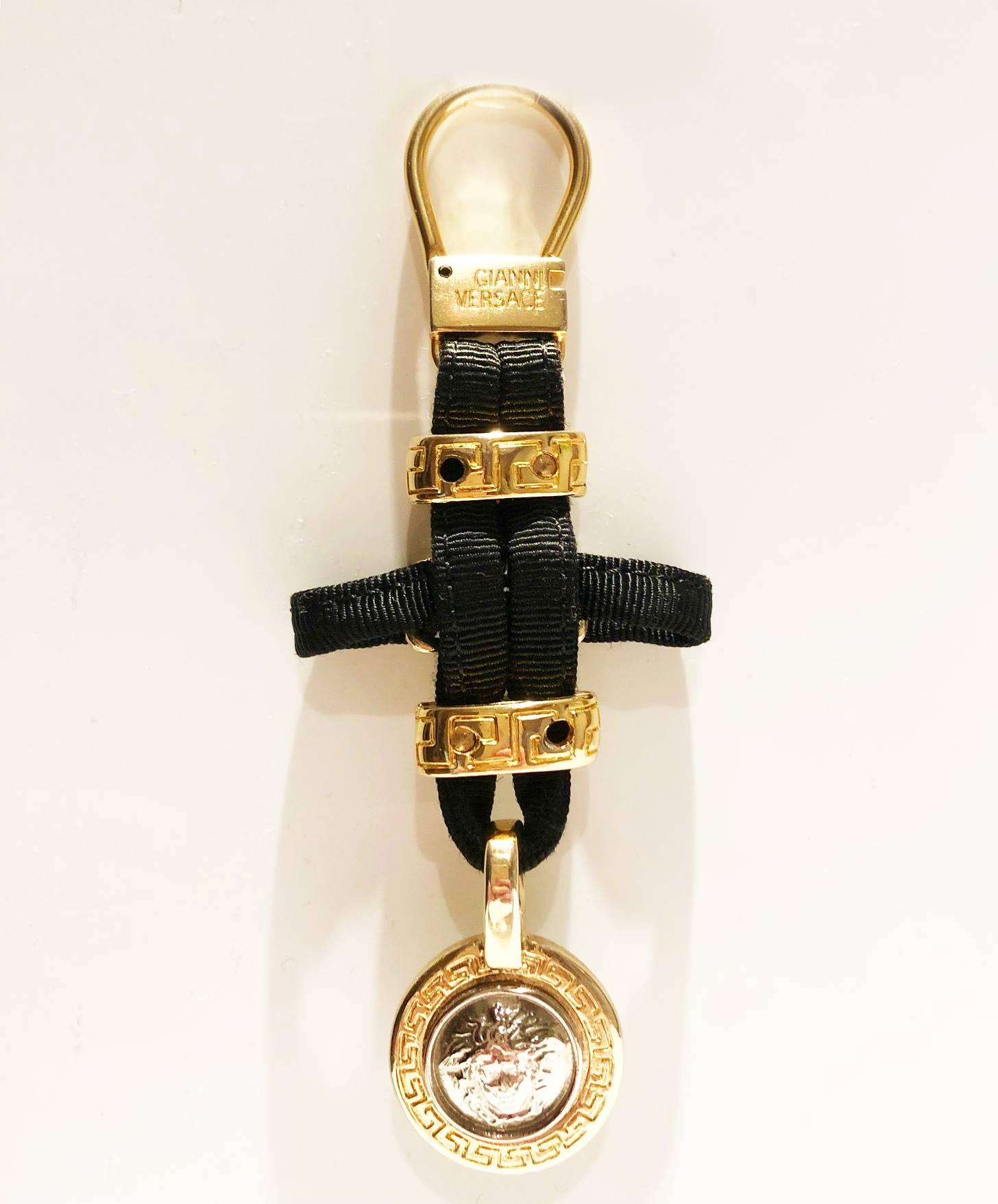 FREE UK and WORLDWIDE DELIVERY 

Iconic Limited Edition Gianni Versace Medusa Medallion key ring bag charm, black grosgrain , gold and silver medusa metal details key ring or bag charm.

Condition: 1990s, vintage, excellent new 
Measurements: 13cm
