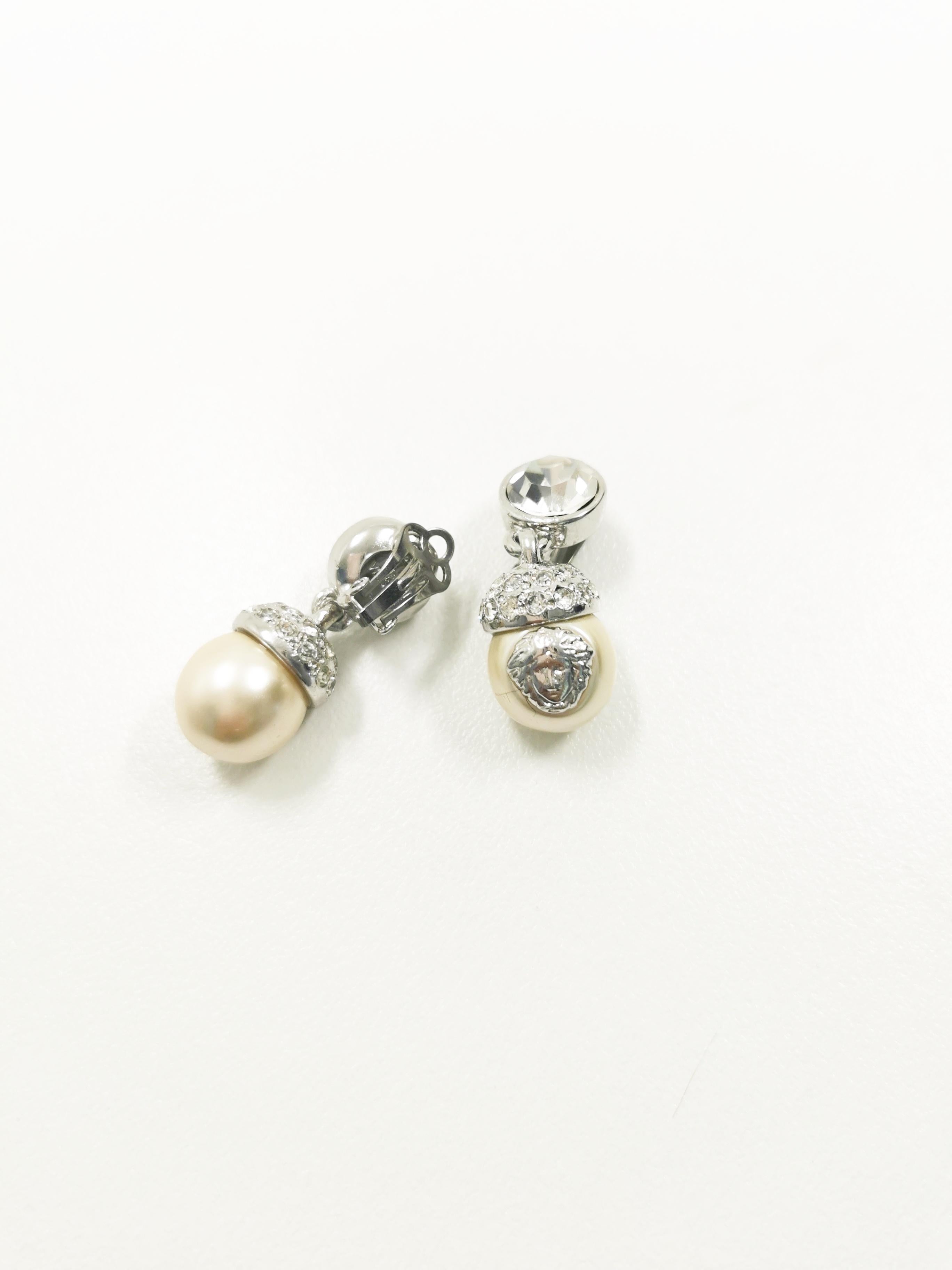 Introducing a timeless piece of luxury fashion history: the 1990's Gianni Versace Medusa Rhinestones Drop Pearl Silver Clip-On Earrings. These exquisite earrings encapsulate the opulence and glamour synonymous with the iconic Italian designer's