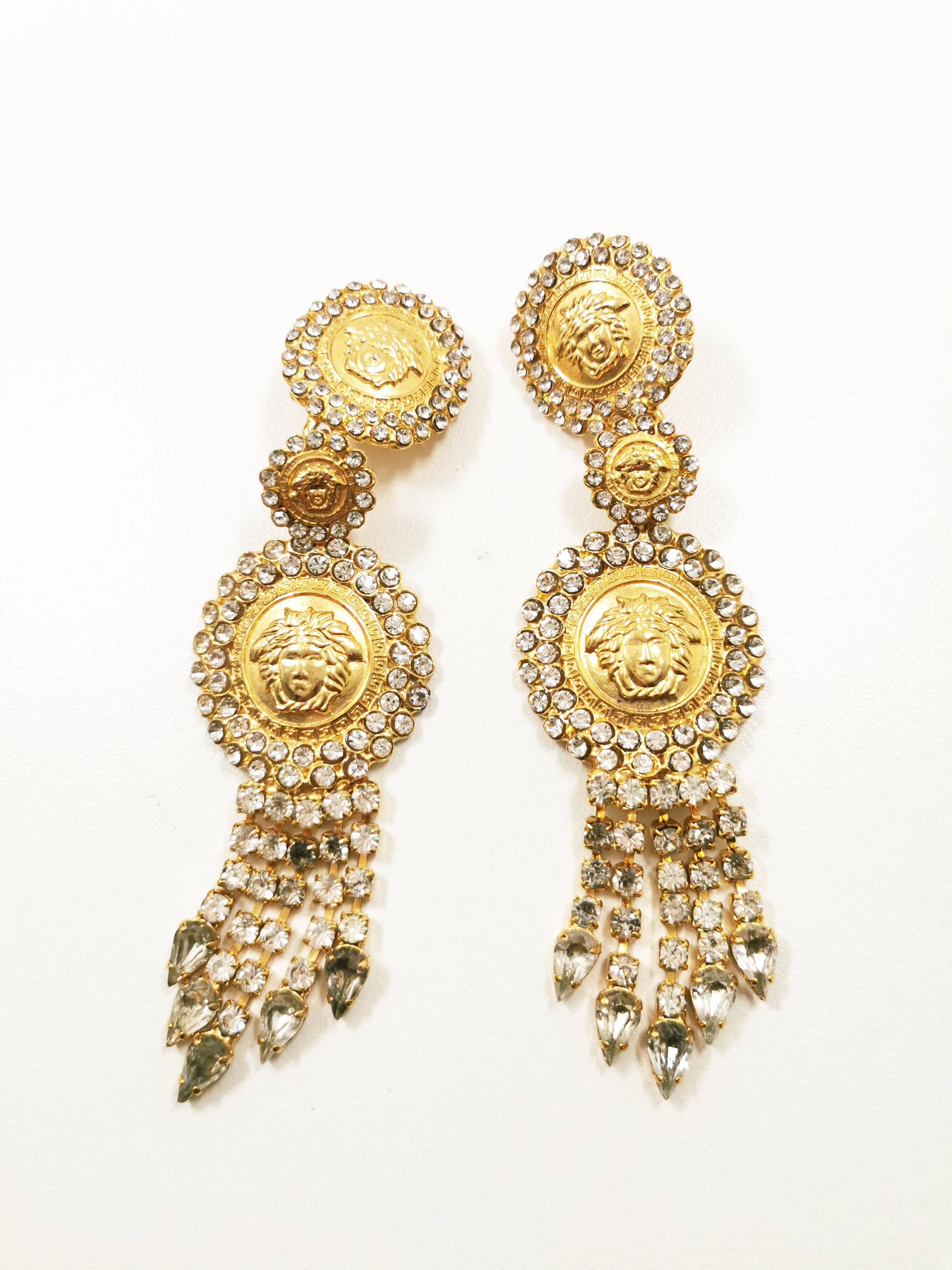 Introducing the iconic and timeless 1990's Gianni Versace Medusa Rhinestones Tassel Massive Drop Earrings – a dazzling tribute to luxury and opulence. These exquisite earrings encapsulate the essence of Versace's bold and distinctive design