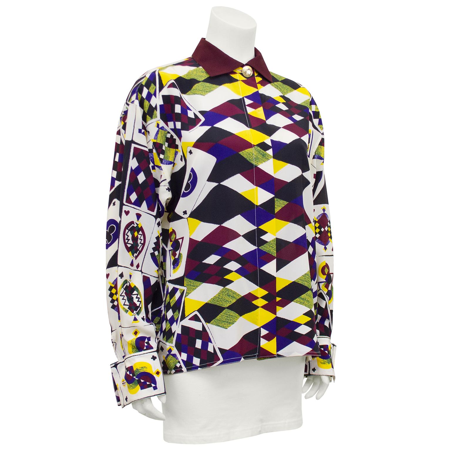 Gianni Versace white label silk shirt from the early 1990s. All over print of abstract playing cards in white, maroon, black, yellow and navy. Solid maroon collar and contrasting gold tone metal button featuring a diamond, a spade and a club. French
