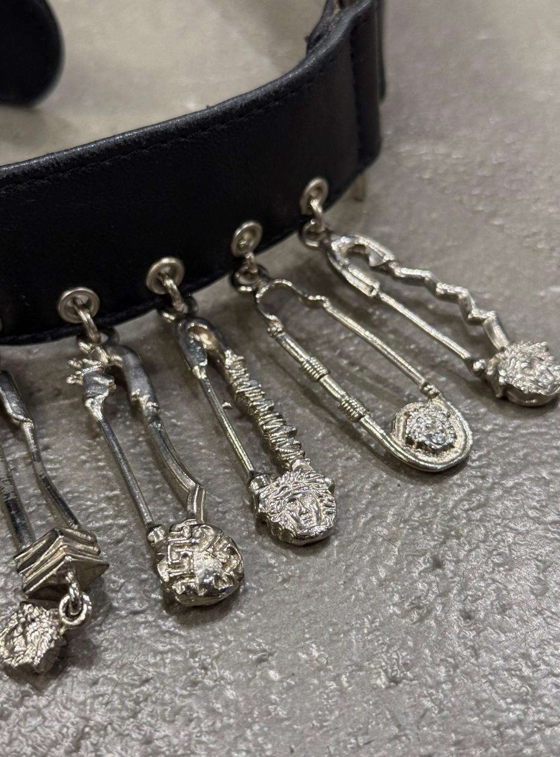 Cintura in pelle con spilla da balia Gianni Versace degli anni '90

Questa cintura di Gianni Versace degli anni '90 è realizzata in pelle nera e ornata con le iconiche spille da balia argentate della maison. Caratterizzata da un'audace fibbia Medusa