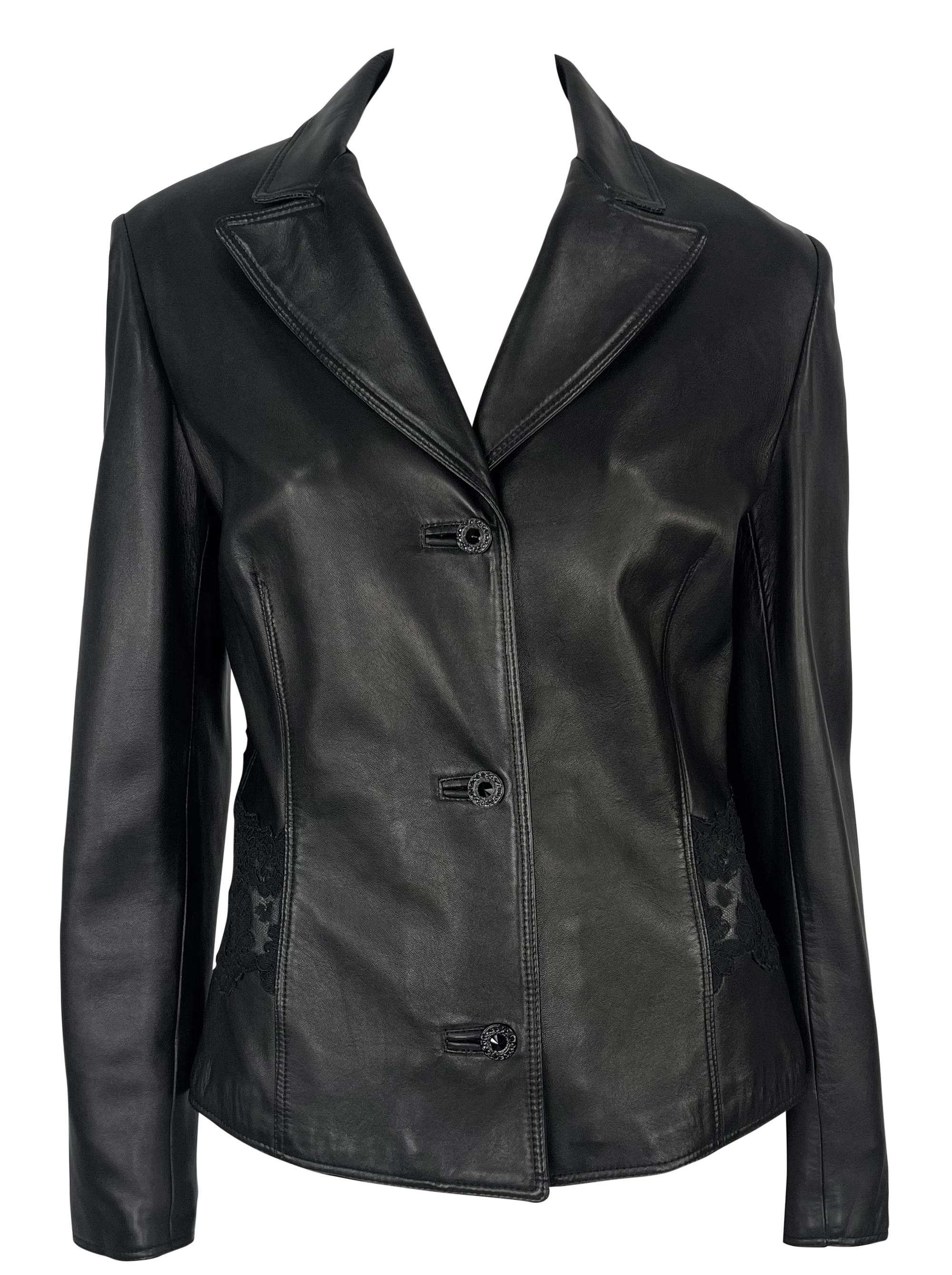 This 1990s Gianni Versace blazer jacket is crafted from smooth black leather and features a tailored, fitted silhouette. A notched lapel collar and three-button closure define the front, while sheer black lace panels on the sides and back add