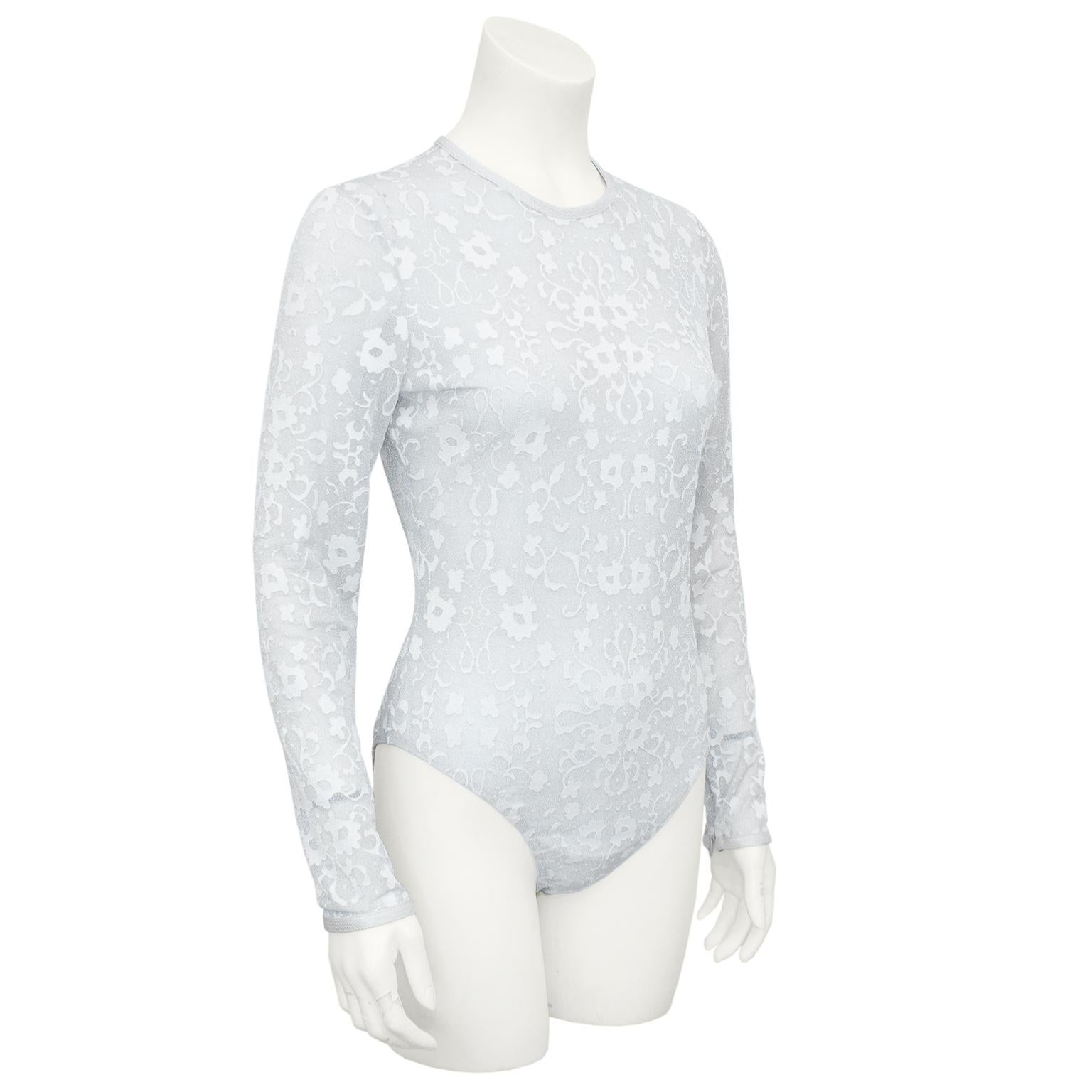 1990s Gianni Versace bodysuit. Sheer lurex lace with silver metallic bits throughout and silver trim with tonal top stitching. Little bit of stretch. Invisible zipper up centre back and hook and eye closures at bottom. Small zipper slits at wrists