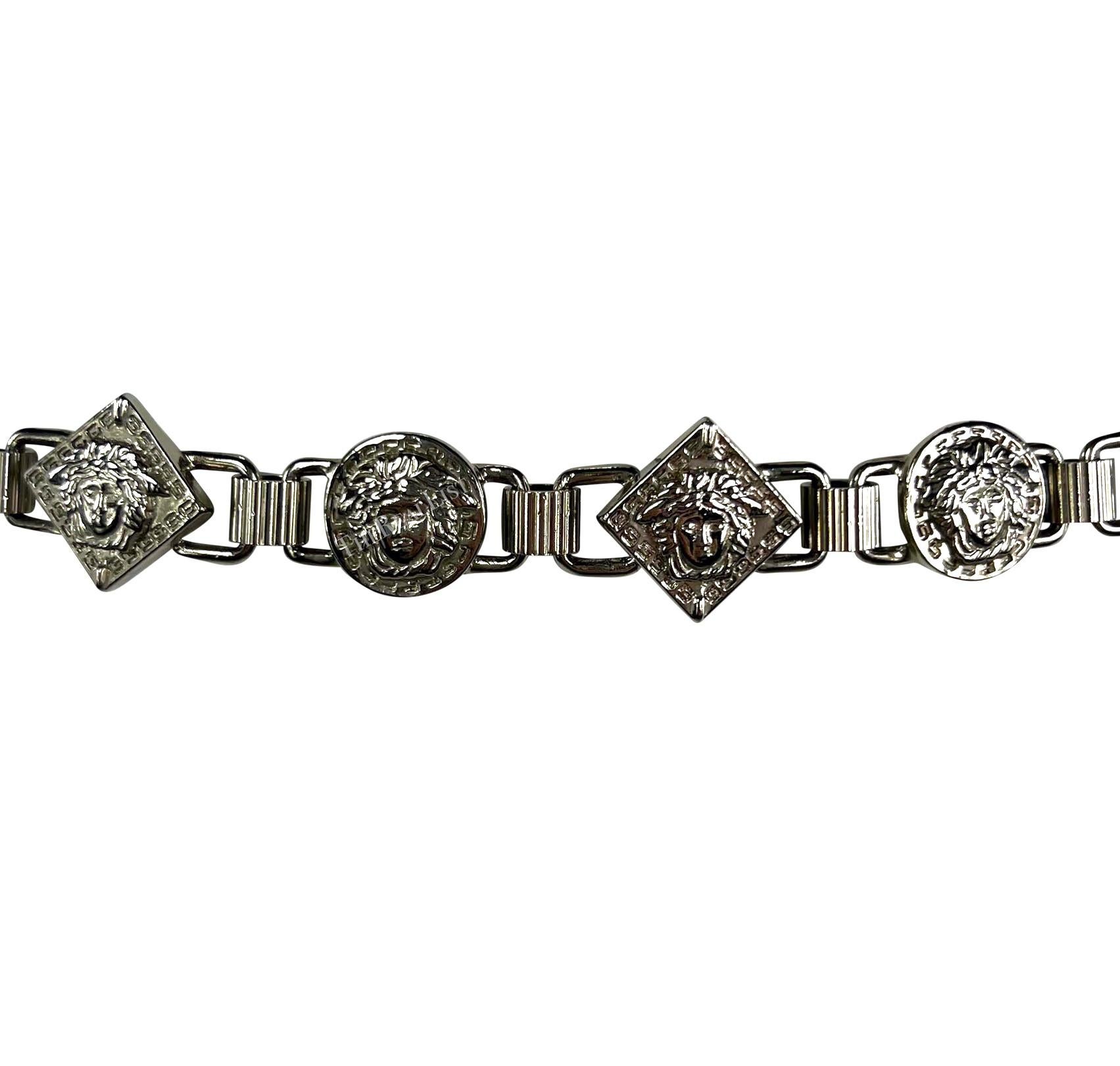 In the 1990s, Gianni Versace created this silver-tone metal belt for his eponymous label. The belt features alternating diamond and circle Medusa reliefs on a chain link design. It also includes an adjustable chain that hangs to one side, adorned