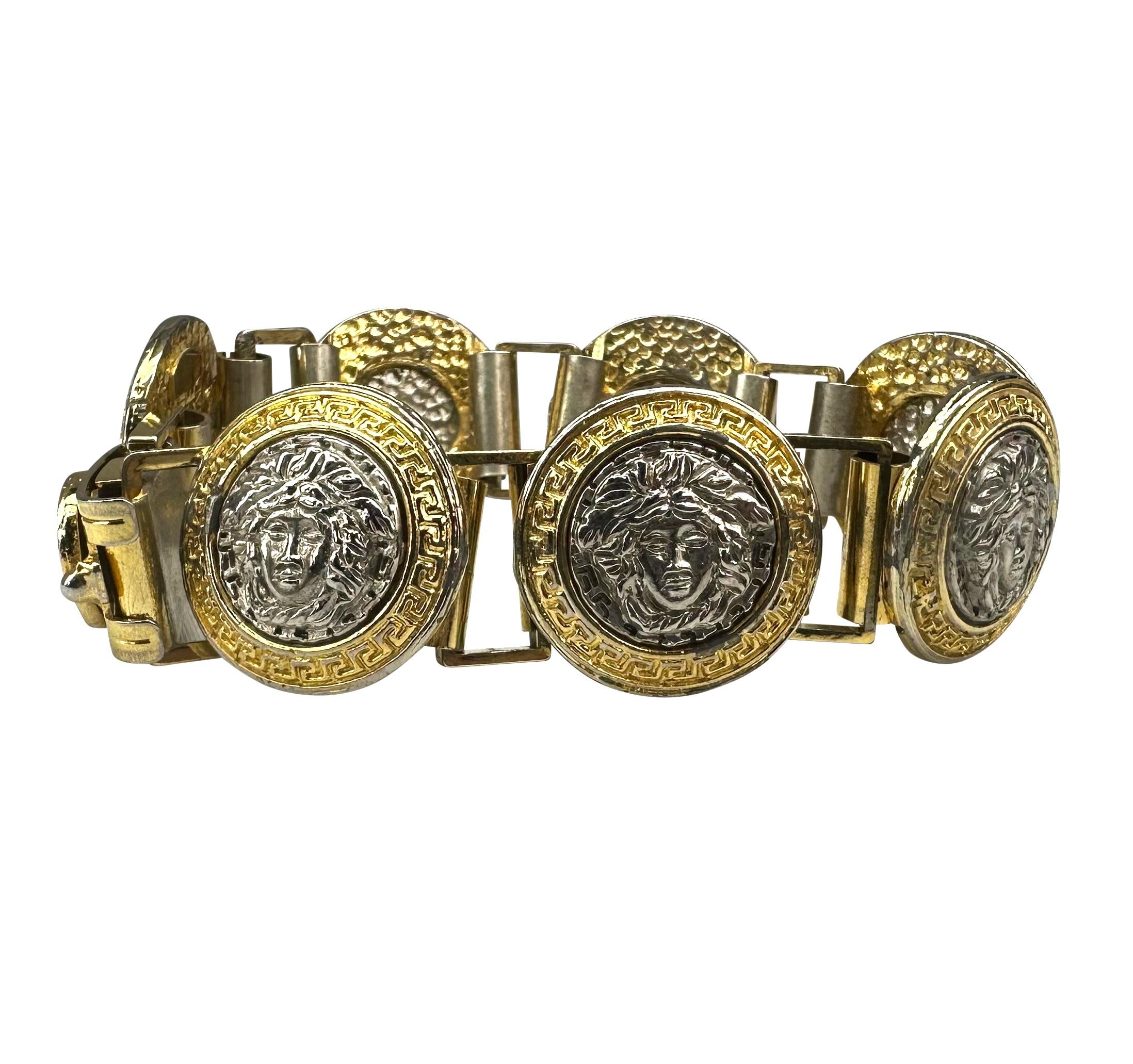 Presenting a two-tone silver and gold Gianni Versace Medusa costume link bracelet. From the 1990s, each link in this bracelet features a silver-tone Versace Medusa logo relief surrounded by a gold-tone greek key border. 

Approximate