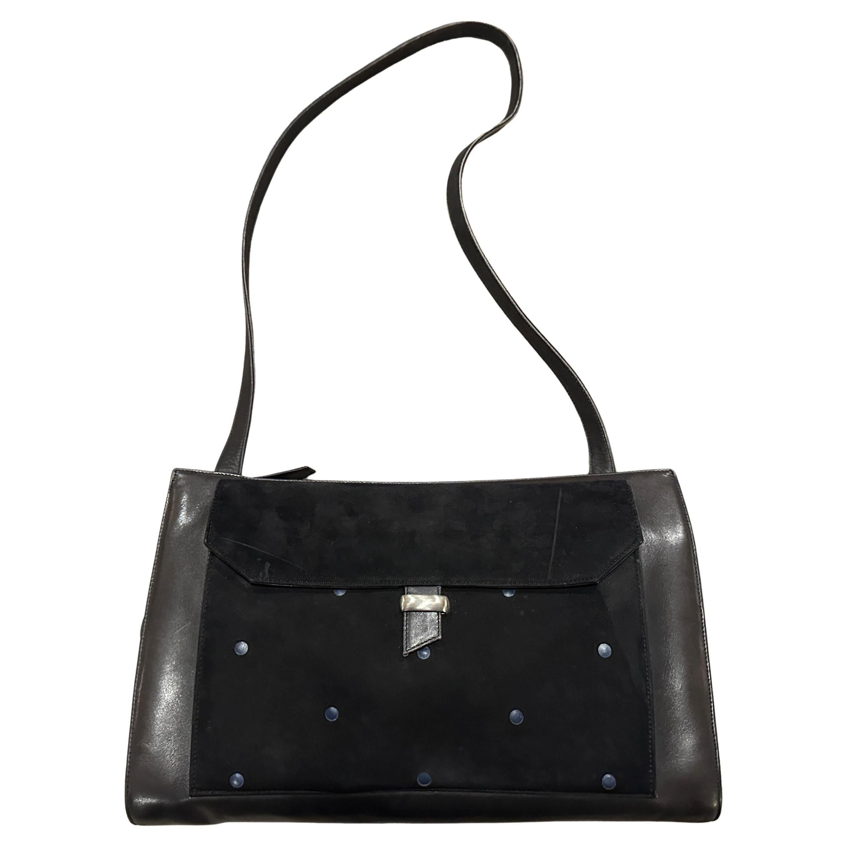 Gianni Versace 1990s Suede and Leather Shoulder Bag
Step back in time with this exquisite Gianni Versace shoulder bag, a true testament to the iconic designer's bold aesthetic of the 1990s. Crafted in Italy, this vintage piece showcases a