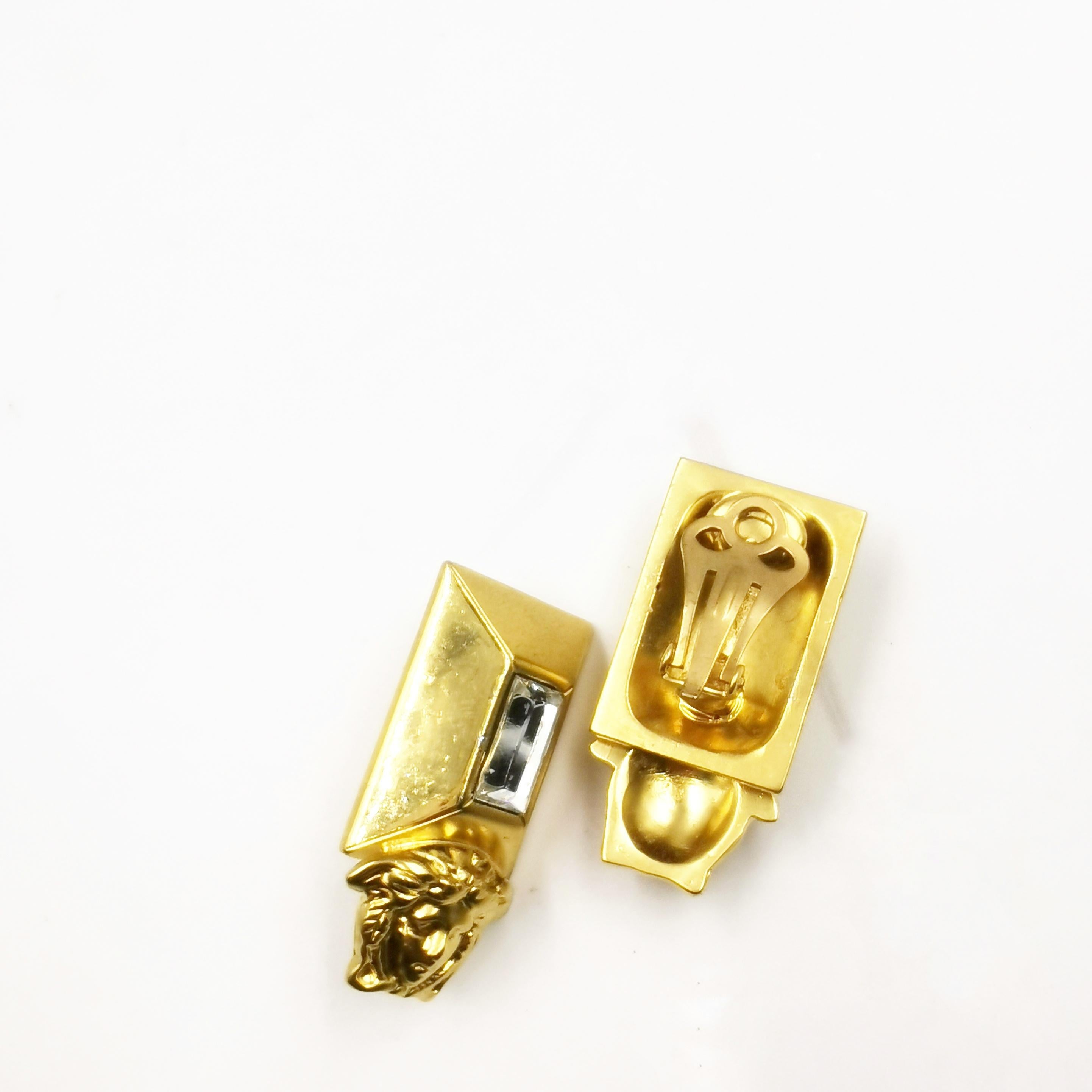 Tauchen Sie ein in die glamouröse Welt der 1990er Jahre mit den atemberaubenden Gianni Versace Vintage Gold Medusa Emerald Cut Crystal Clip On Earrings. Diese atemberaubenden Ohrringe fangen die Essenz der ikonischen Ästhetik von Versace ein und