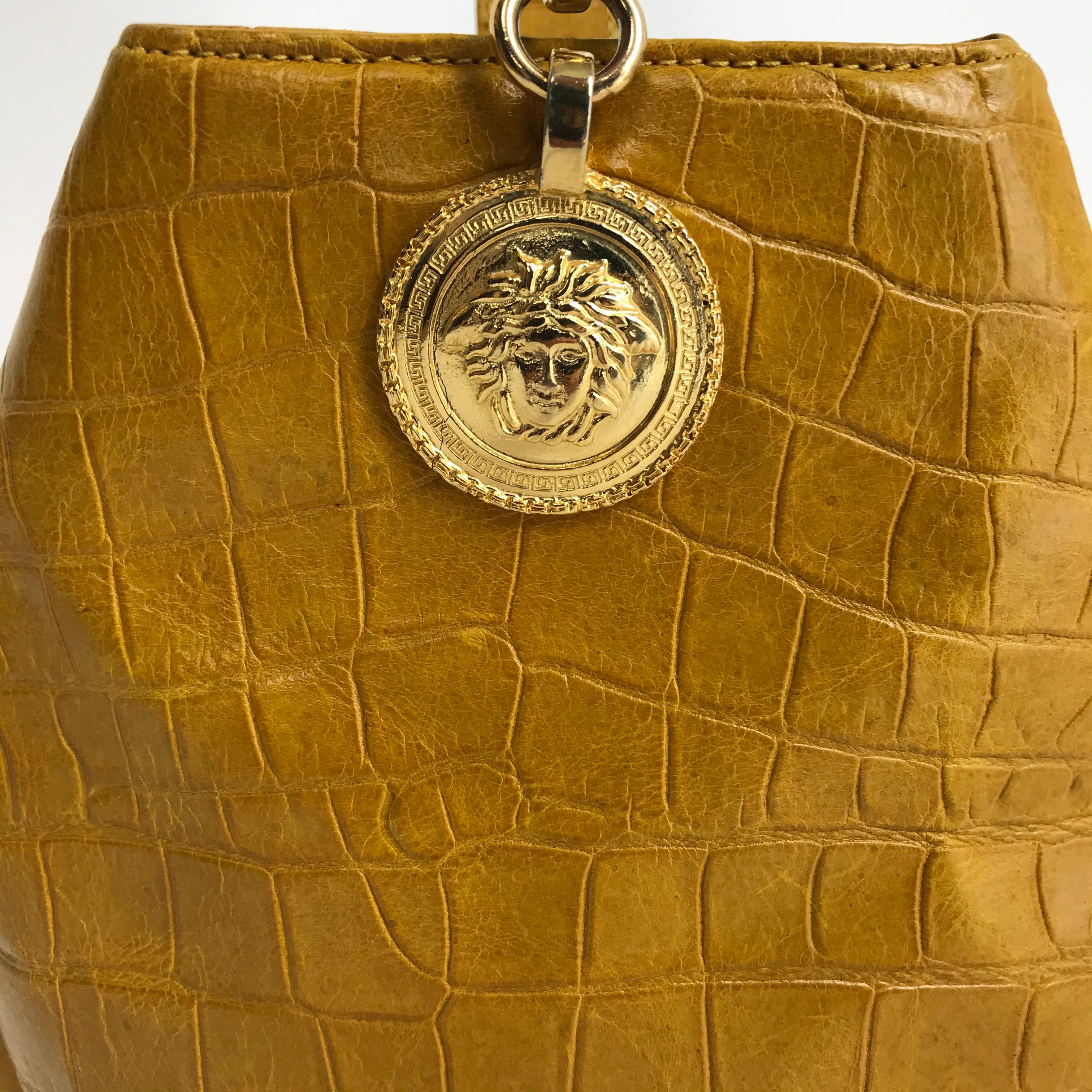 GIANNI VERSACE, Made in Italy, circa 90's. 
Yellow crocodile print bucket bag in good condition. Medusa emblem on gold-tone hardware. 
Height : 23cm / width : 21cm  

Every item is rare and carefully selected. Measurements, quality, material, and