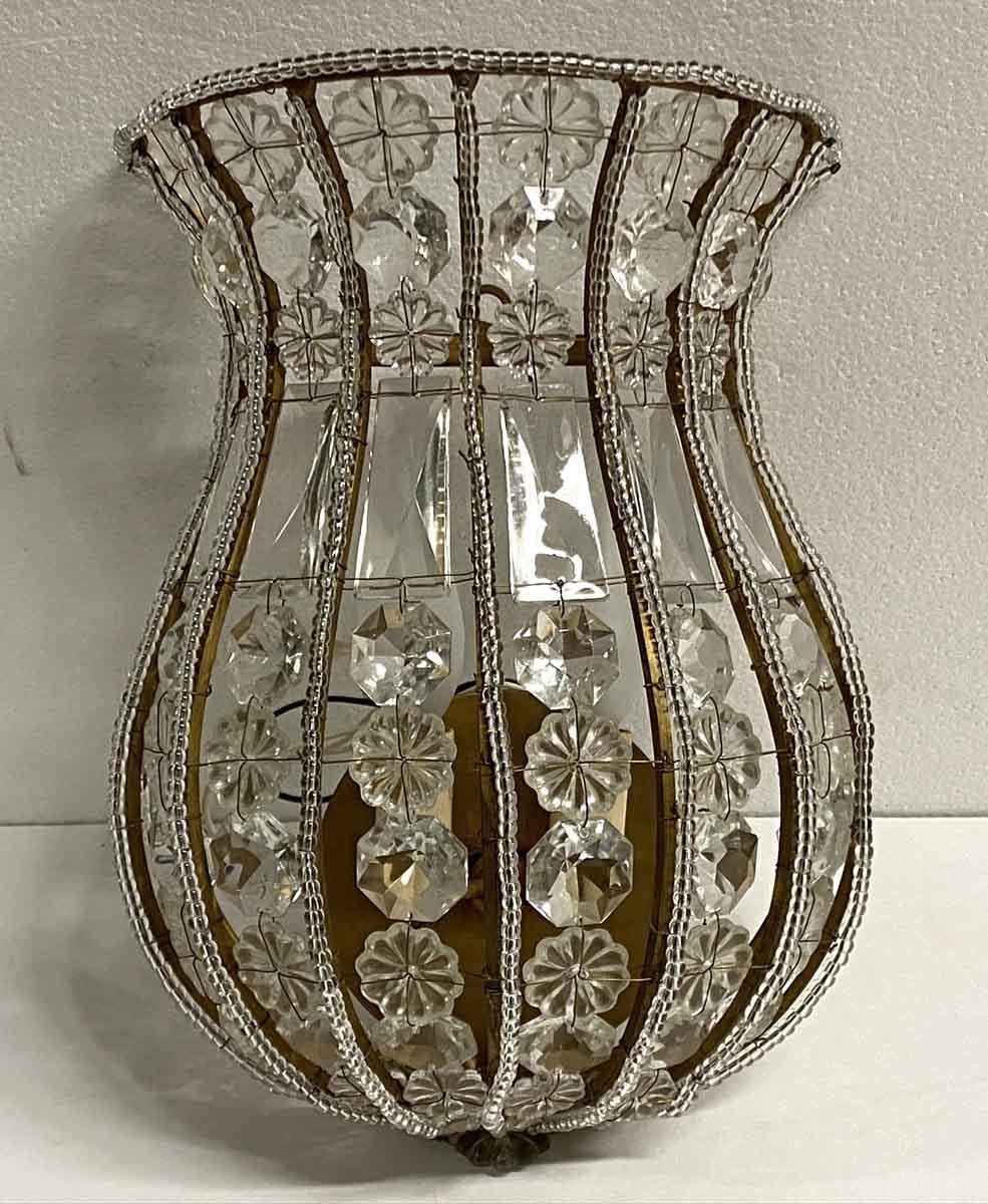 2000s gilt metal ribbed frame Venetian clear crystal basket wall sconce featuring decorative beading and finished off with alternating cut crystals. Accepts two candelabra bulbs. Price includes restoration.  Size: 12 in. high. Small quantity