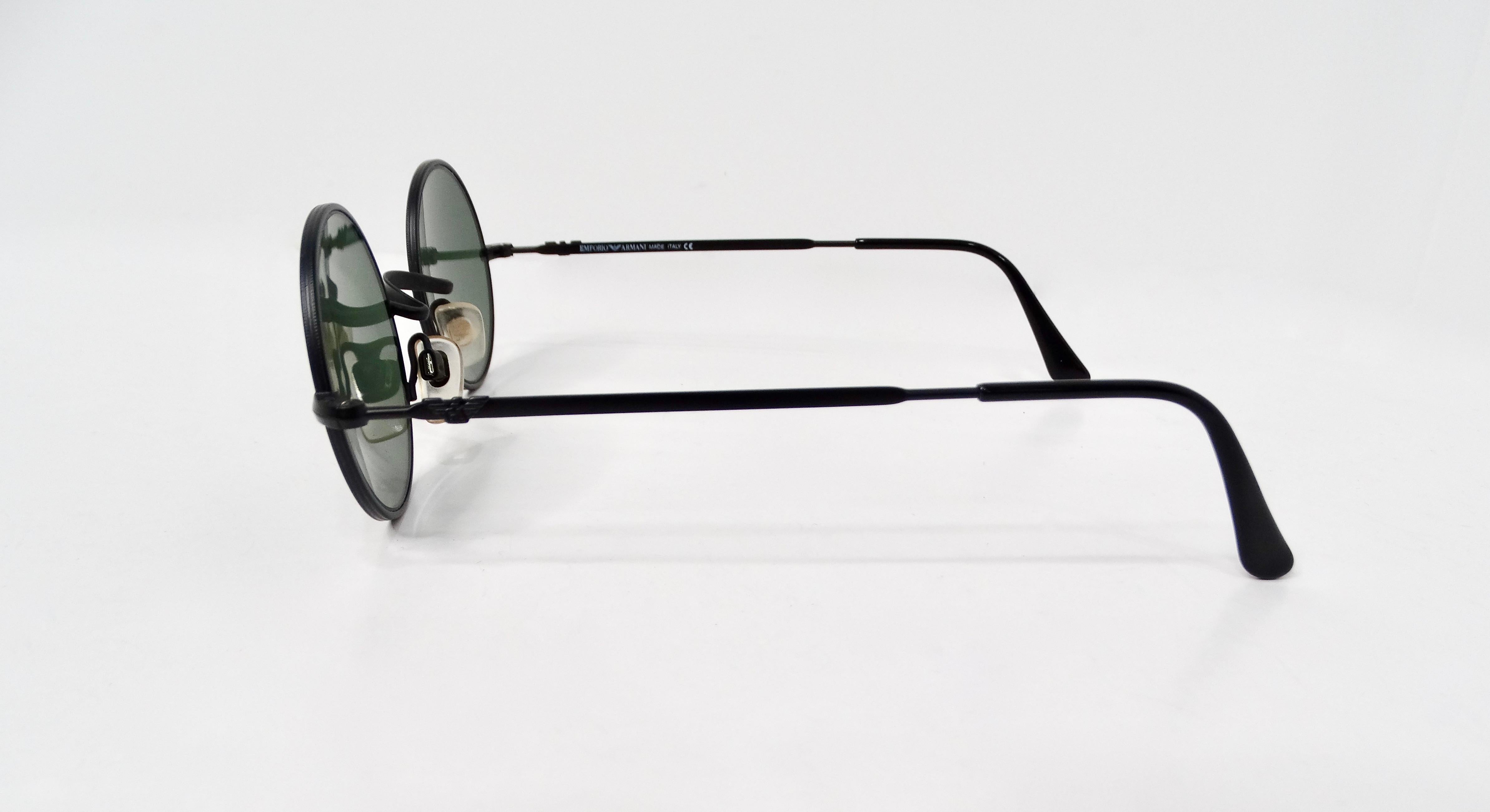 Step into the world of quintessential 90s fashion with these Giorgio Armani Black Metal Round Frame Sunglasses, a striking accessory that captures the era's avant-garde aesthetic. Featuring green-tinted lenses that provide a unique touch while