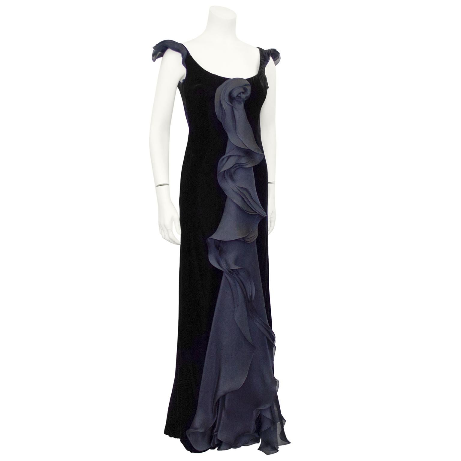 This Giorgio Armani jet black cut velvet gown from the 1990s is so gorgeous and etherial. Sleeveless with a wide scoop neckline and sheath shape. The eye-catching moment of this gown is the stunning layered and ruffled black chiffon that starts with