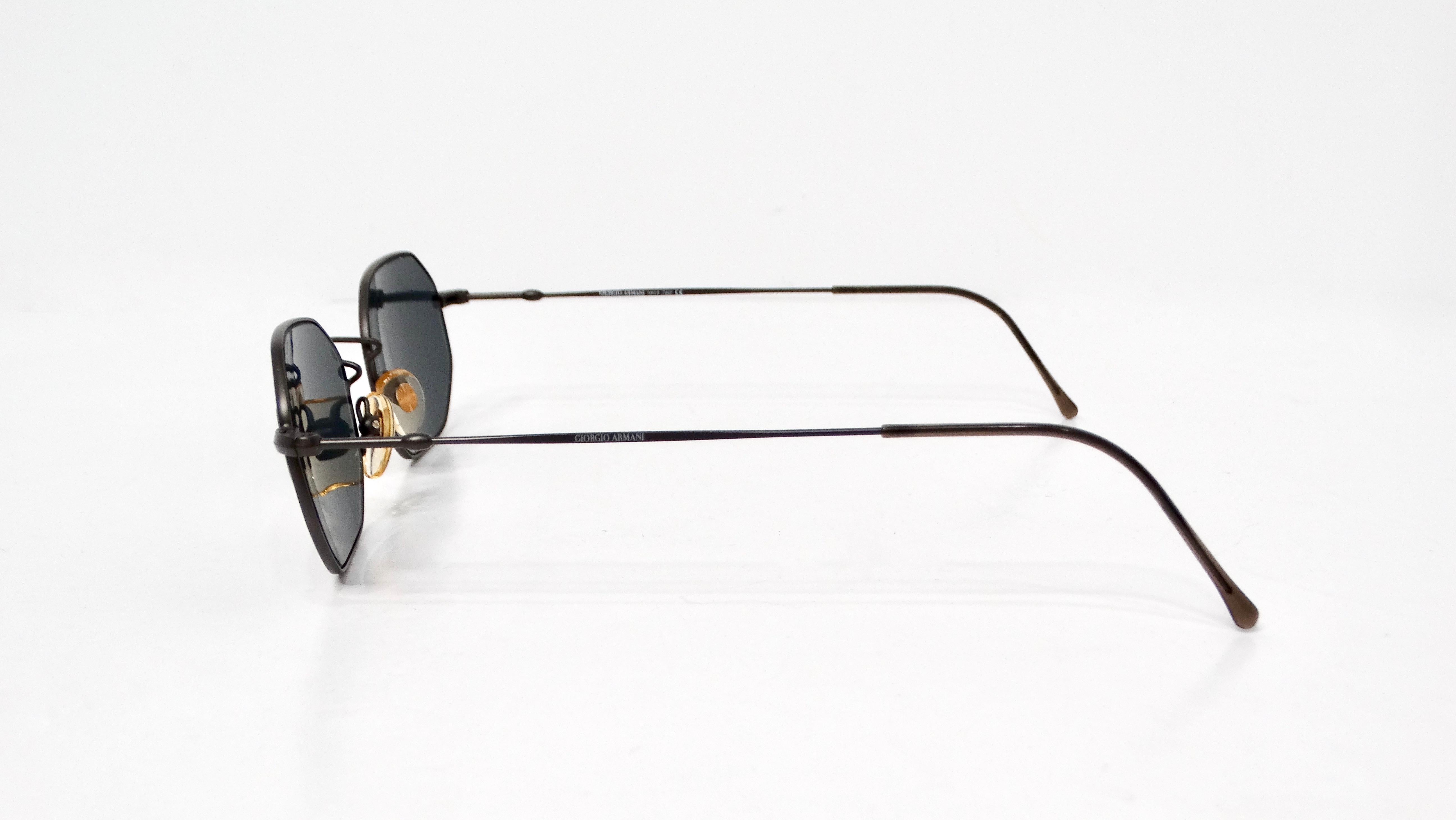 Step into the world of iconic fashion with these 1990s Giorgio Armani Geometric Black Metal Frame Tinted Sunglasses. Characterized by their unique hexagonal shape, these shades epitomize the bold and innovative design ethos of the era. The sleek