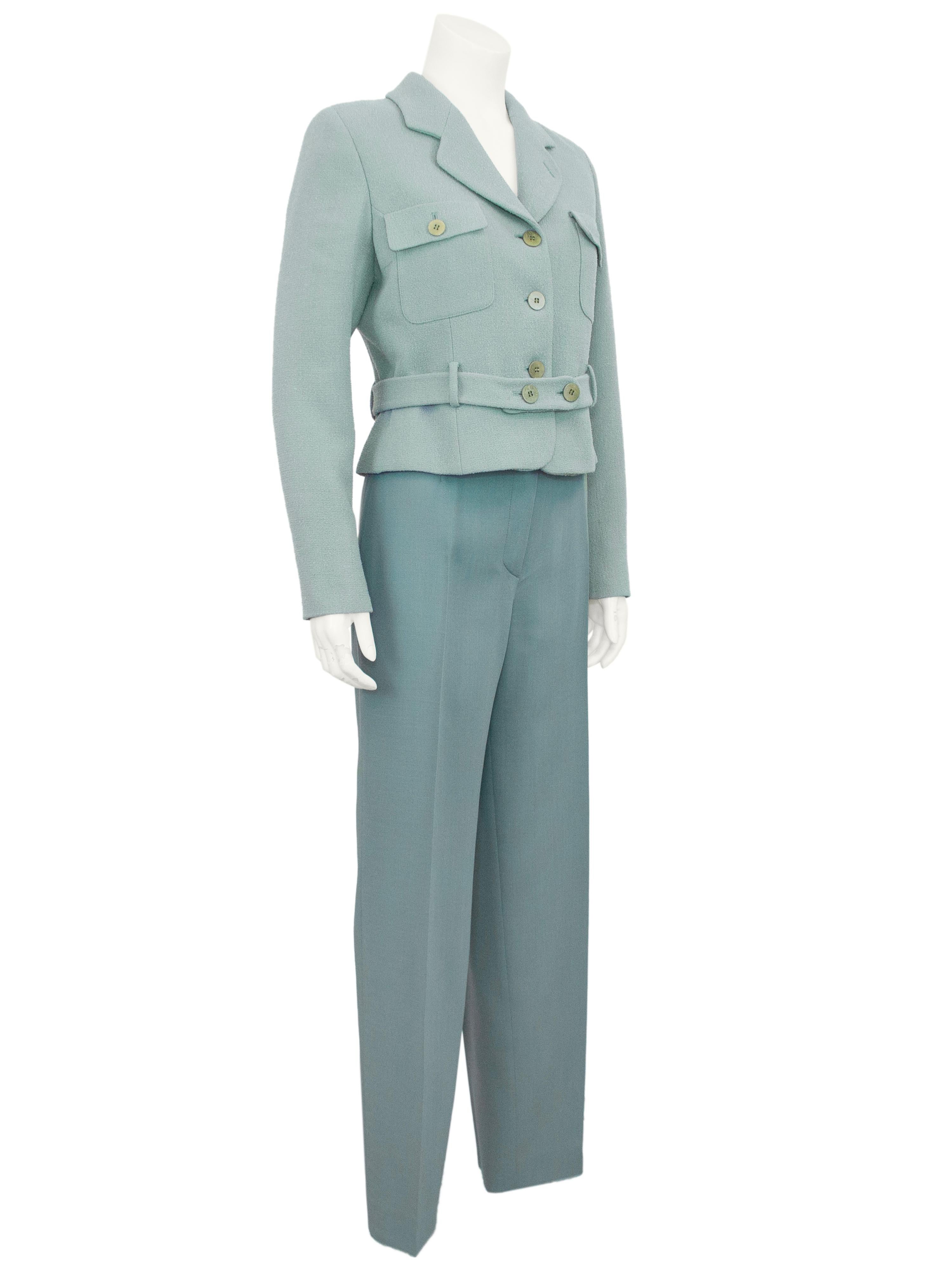 Completo giacca e pantaloni molto chic di Giorgio Armani Le Collezioni degli anni '90. La giacca in crêpe di lana verde Sage è tagliata con un colletto dentellato, tasche applicate con patta sul busto e una cintura in vita. I pantaloni a gamba tesa