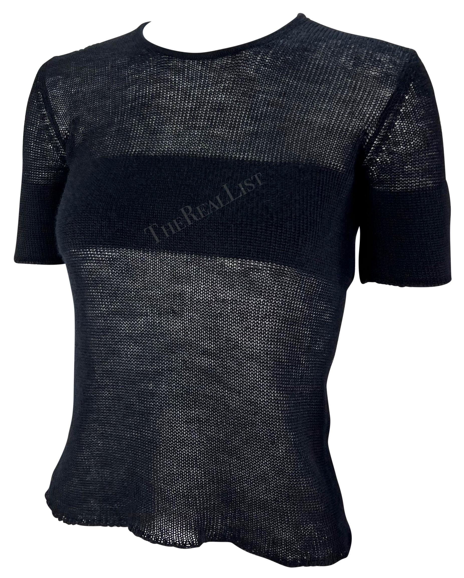 From the 1990s, this fabulous navy blue knit Giorgio Armani short sleeve shirt semi-sheer top is entirely constructed of knit cashmere. The upper part of the top is snugly woven to cover and fit around the bust and arms, while the lower part of the