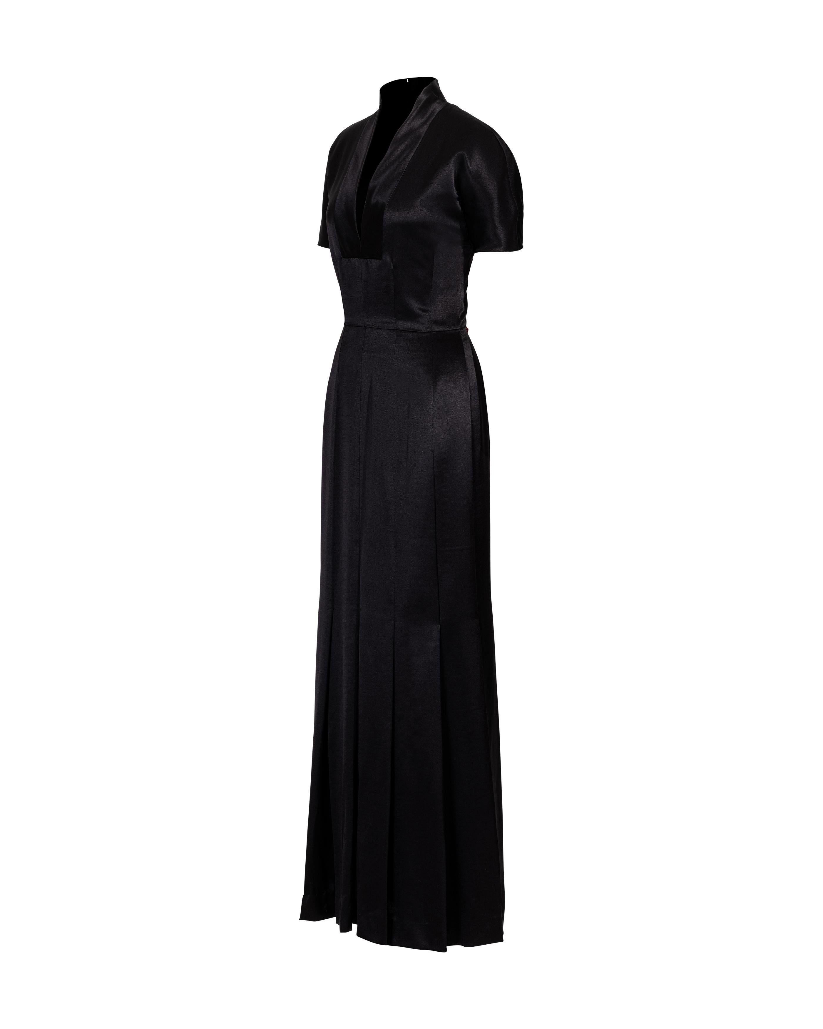 1990's Givenchy by Alexander McQueen black short sleeve pleated gown. Short sleeve, v-neck gown with fitted waist and full, pleated skirt. Concealed center-back zip closure. Fabric Contents: 60% Wool, 40% Silk with 100% Silk lining. Marked size FR