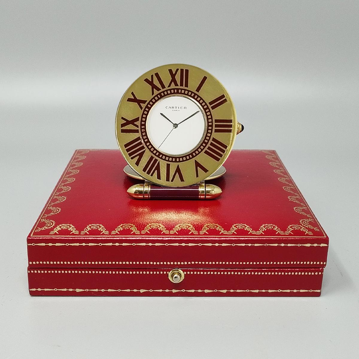 1990s Gorgeous Cartier alarm clock pendulette with white dial in perfect condition, steel hands, roman hour markers on gold-plated frame.  Made in France.
Quartz movement. Clock case numbered 357105581 with original case, lined with red leather. It