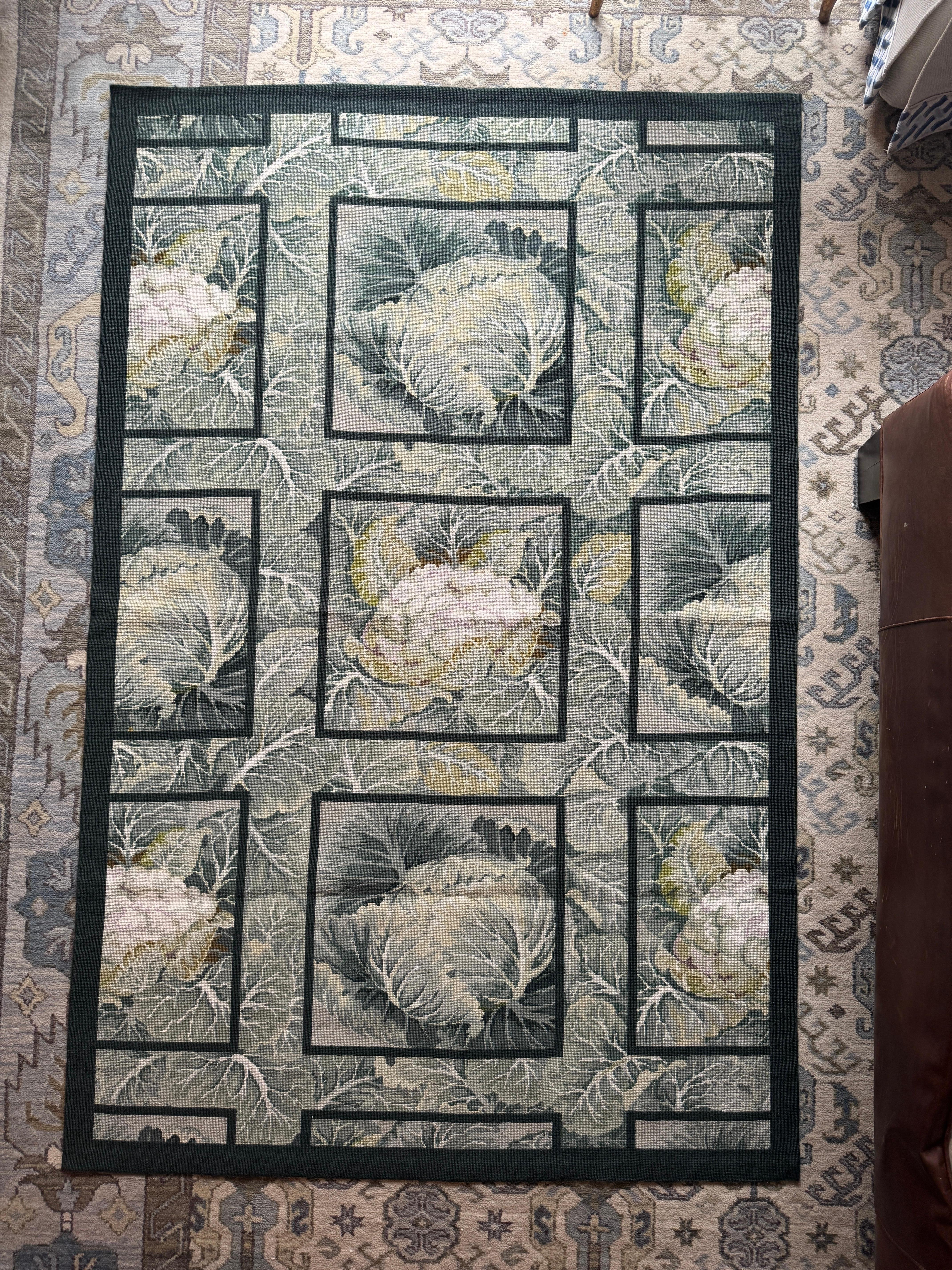 Offered is an exquisite 1990s needlepoint rug in rich shades of cream and green, depicting lettuce and cabbages in bordered squares. The styling and motif recalls the understated natural elegance of interiors by American style icon Bunny Mellon's