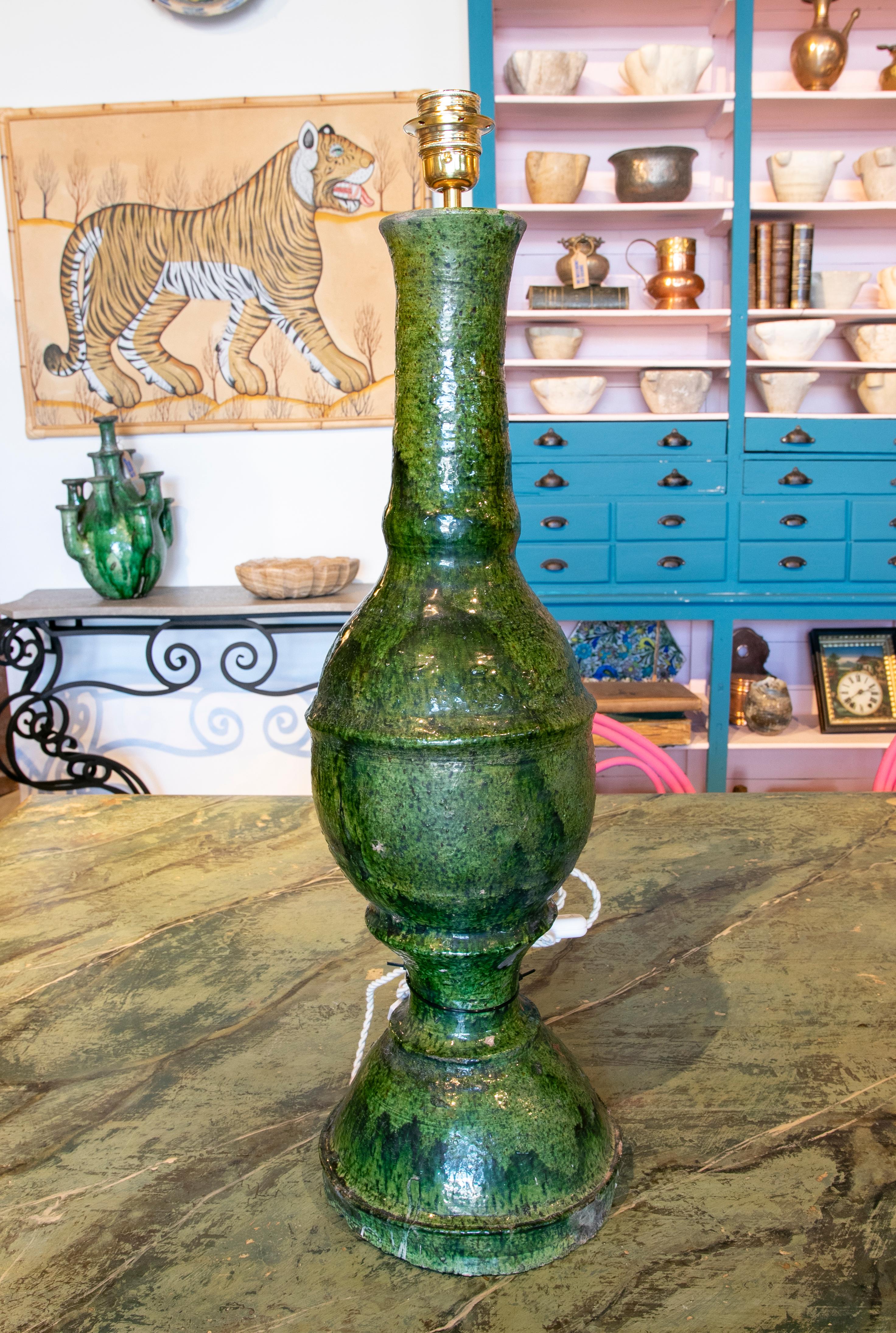 Green glazed ceramic table lamp from the 1990ies with white cord and golden socket.