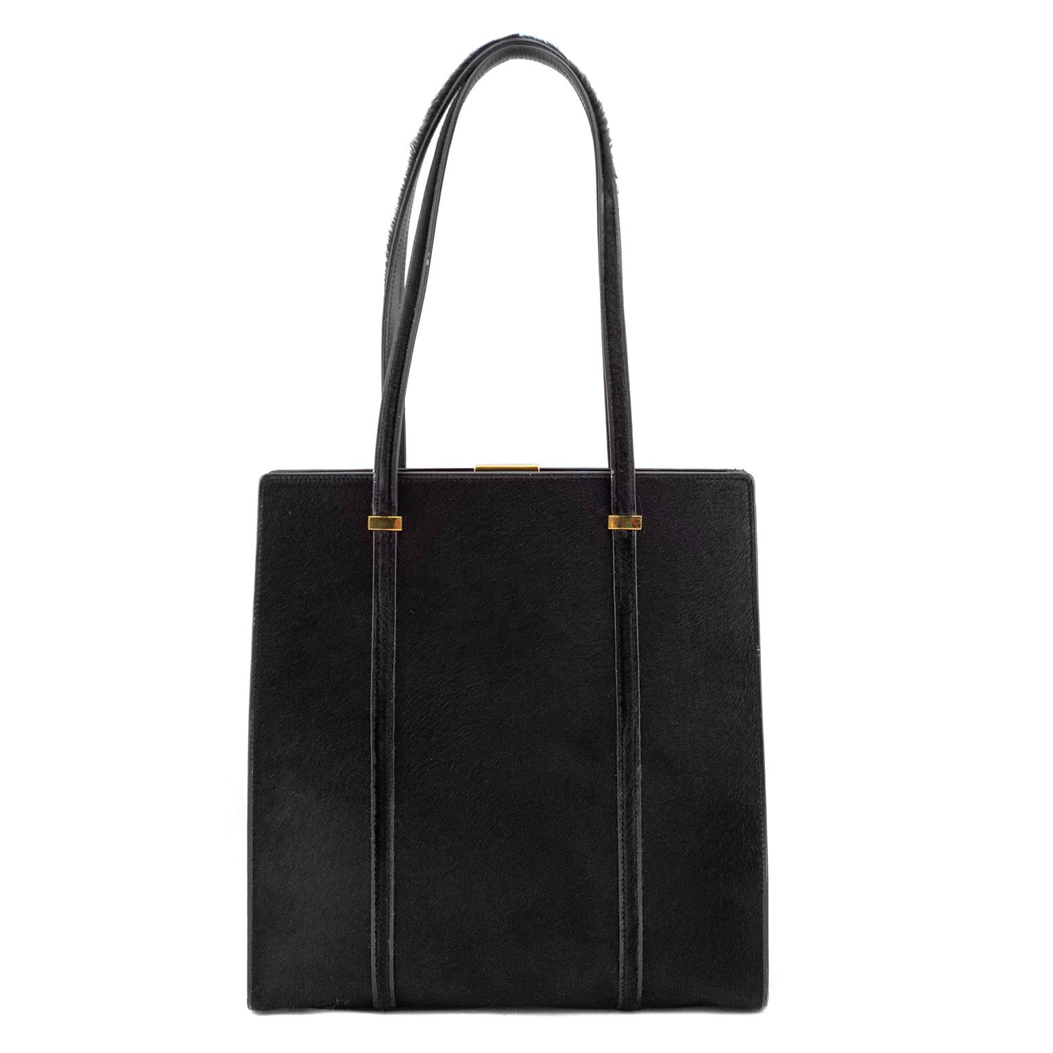 Uber chic and minimalistic 1990's Gucci frame bag. Black pony hair with monochromatic black leather trim and gold hardware. Long top handles allow to sit on shoulder. Gold metal Gucci engraved metal closure. Black leather interior with single