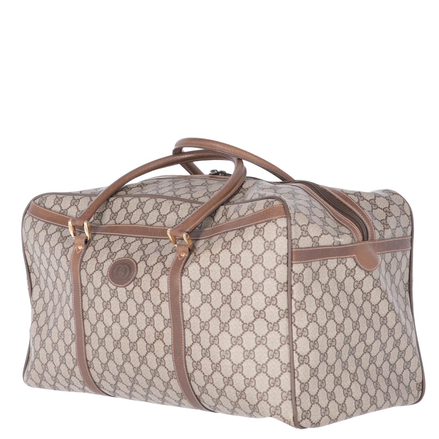 A.N.G.E.L.O. Vintage - ITALY 

Gucci GG monogram canvas travel bag with brown leather details. Double slider zip closure, two rigid handles and metal feet on the bottom. Large external pocket and one internal with zip.

The product has some signs of