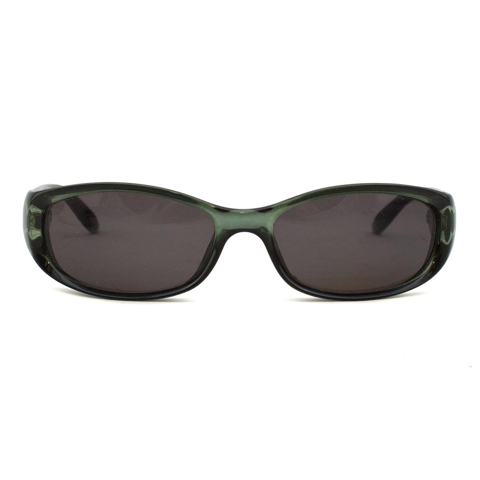 1990s green resin sunglasses. Dark silver Gucci square G logo on arm exterior and all other Gucci markings stamped in white on interior of arms. Black lenses. Made in Italy. Excellent vintage condition. Sold without original case. 