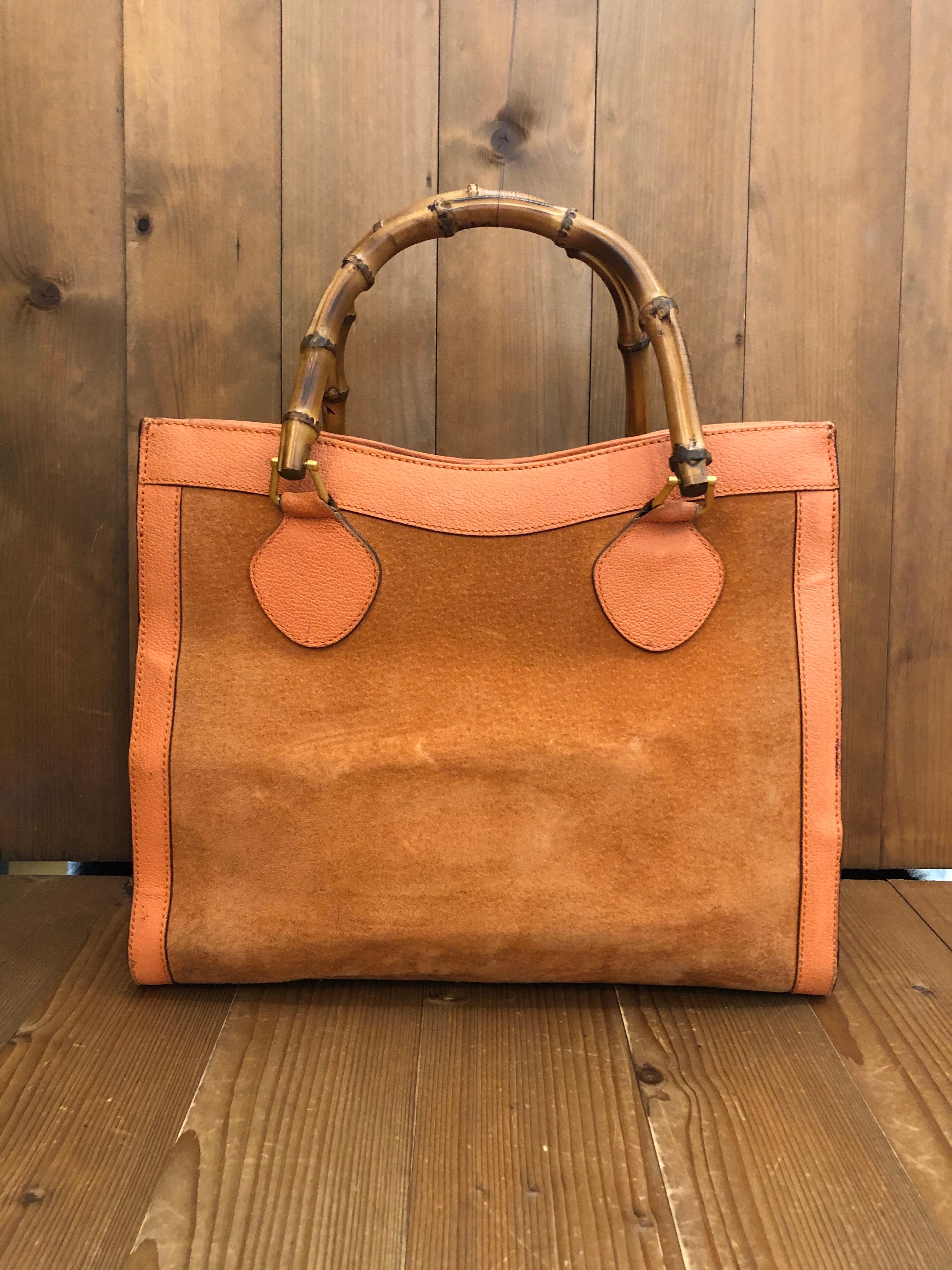 1990s Gucci bamboo tote in orange suede and leather featuring two main open compartments and one middle zip compartments with 1 interior zip pocket. Made in Italy. Measures 13 x 11 x 5.5 inches handle drop 5 inches. The Bamboo tote is one of