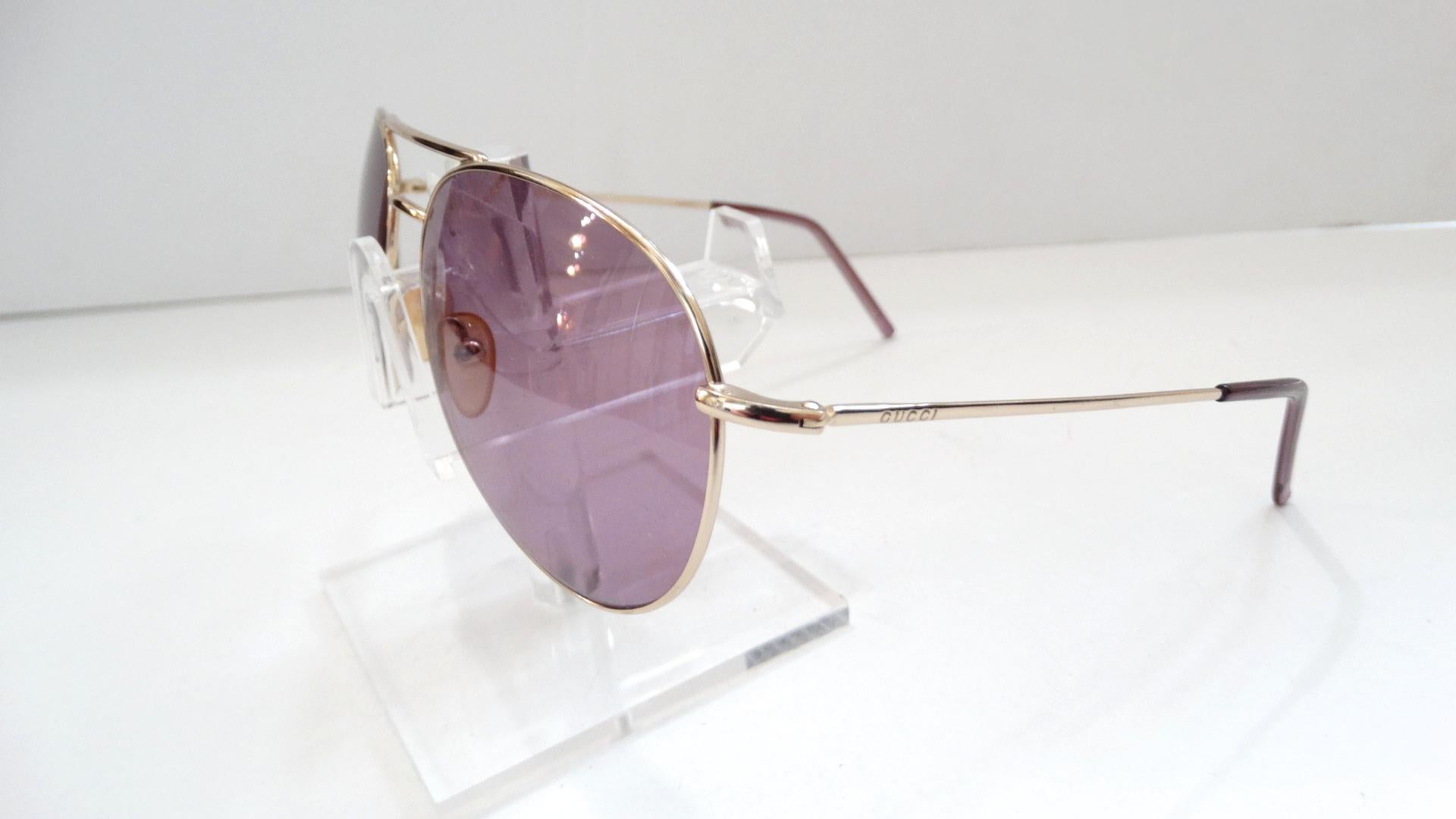In Need Of A New Favorite Pair Of Sunnies? These 1990s Gucci aviators are perfect! These dead stock Gucci sunglasses feature silver hardware and semi clear purple tinted lenses. Includes purple temple covers and is stamped 