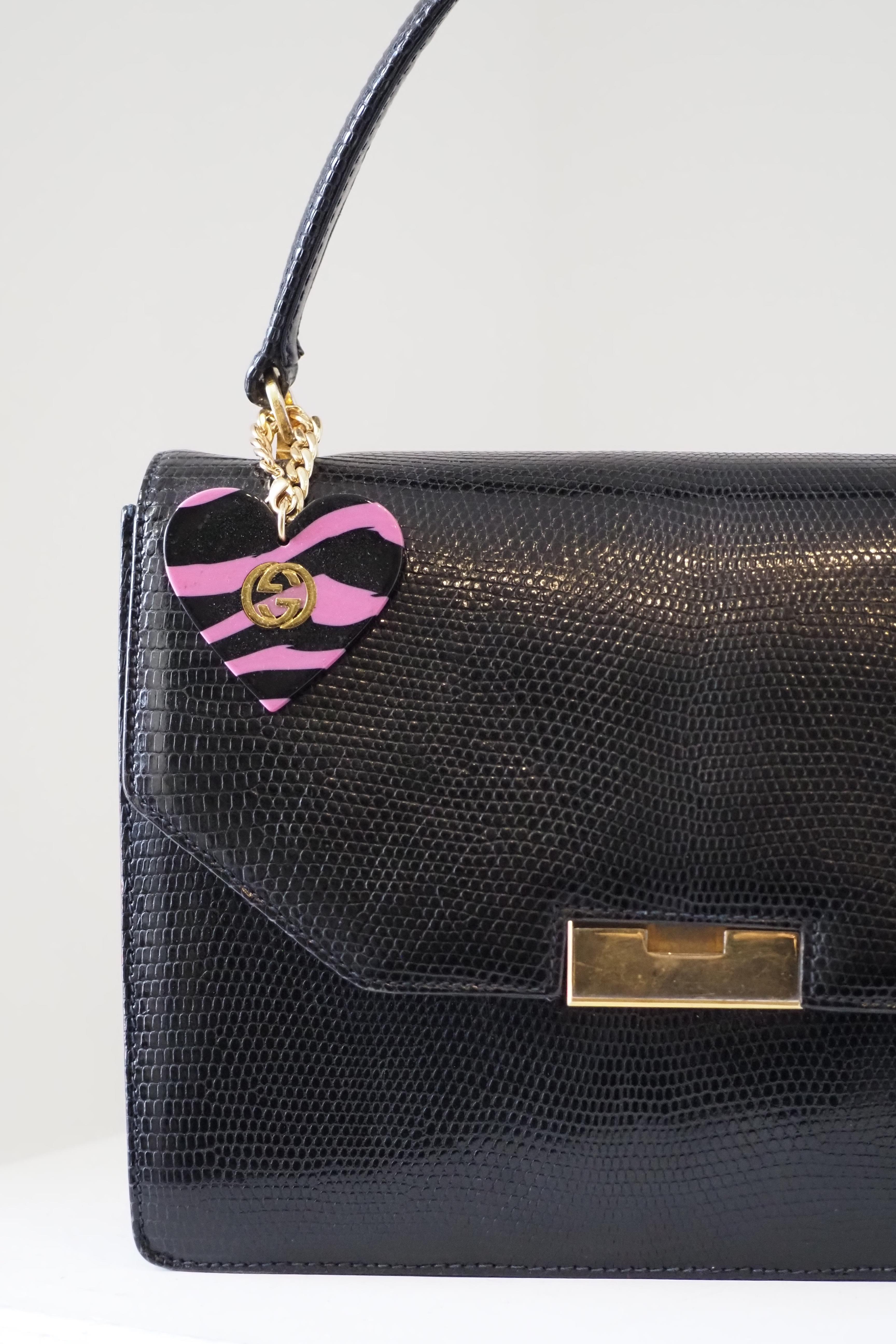 1990s Gucci vintage lizard handle bag with pink black gold heart charm 
totally made in italy in black lizard leather, gold tone hardware embellished with gold, black and pink heart charm on the handle.
on the back there is a pocket
in the inside a