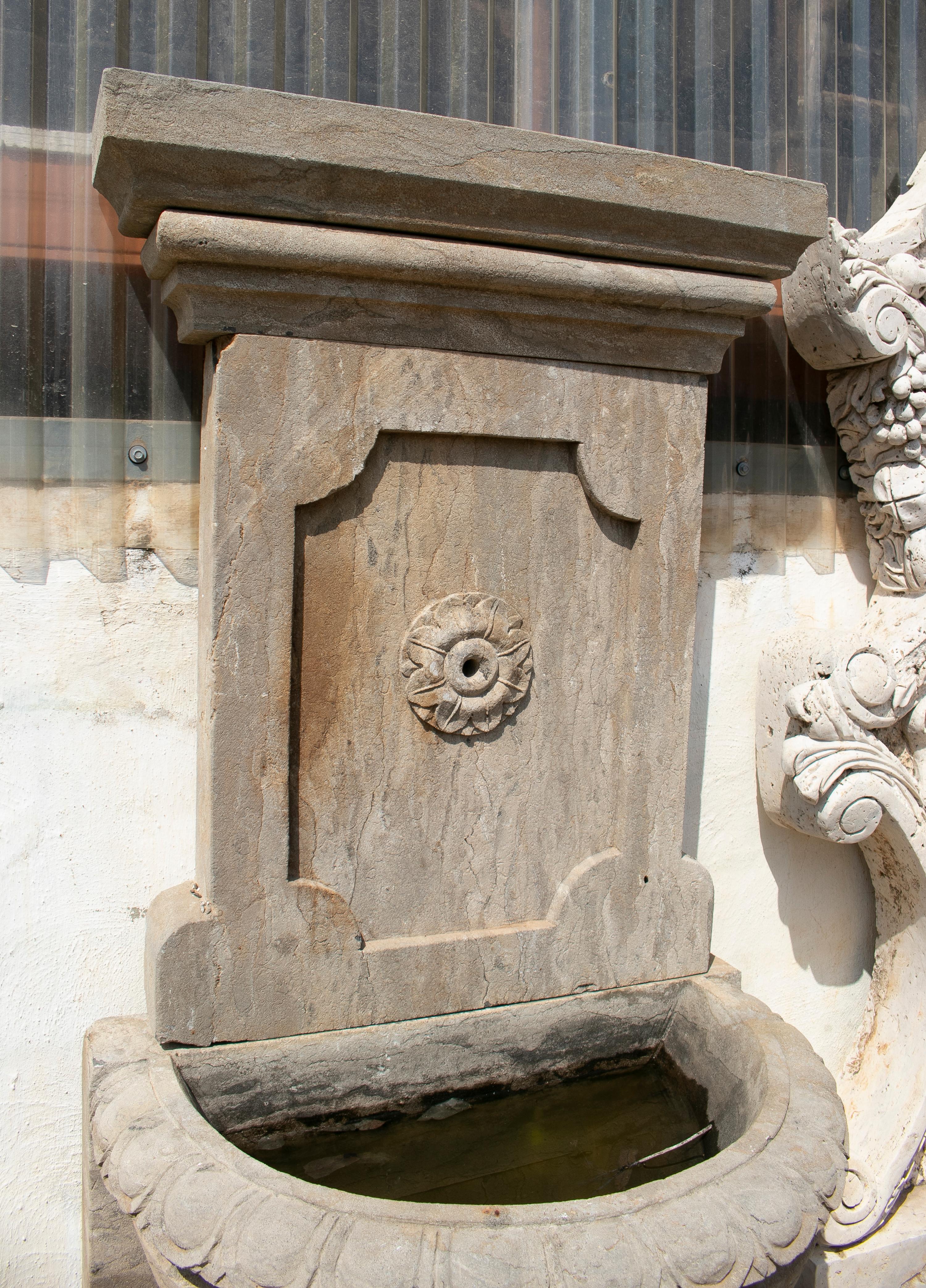 1990s hand carved aged stone wall fountain.