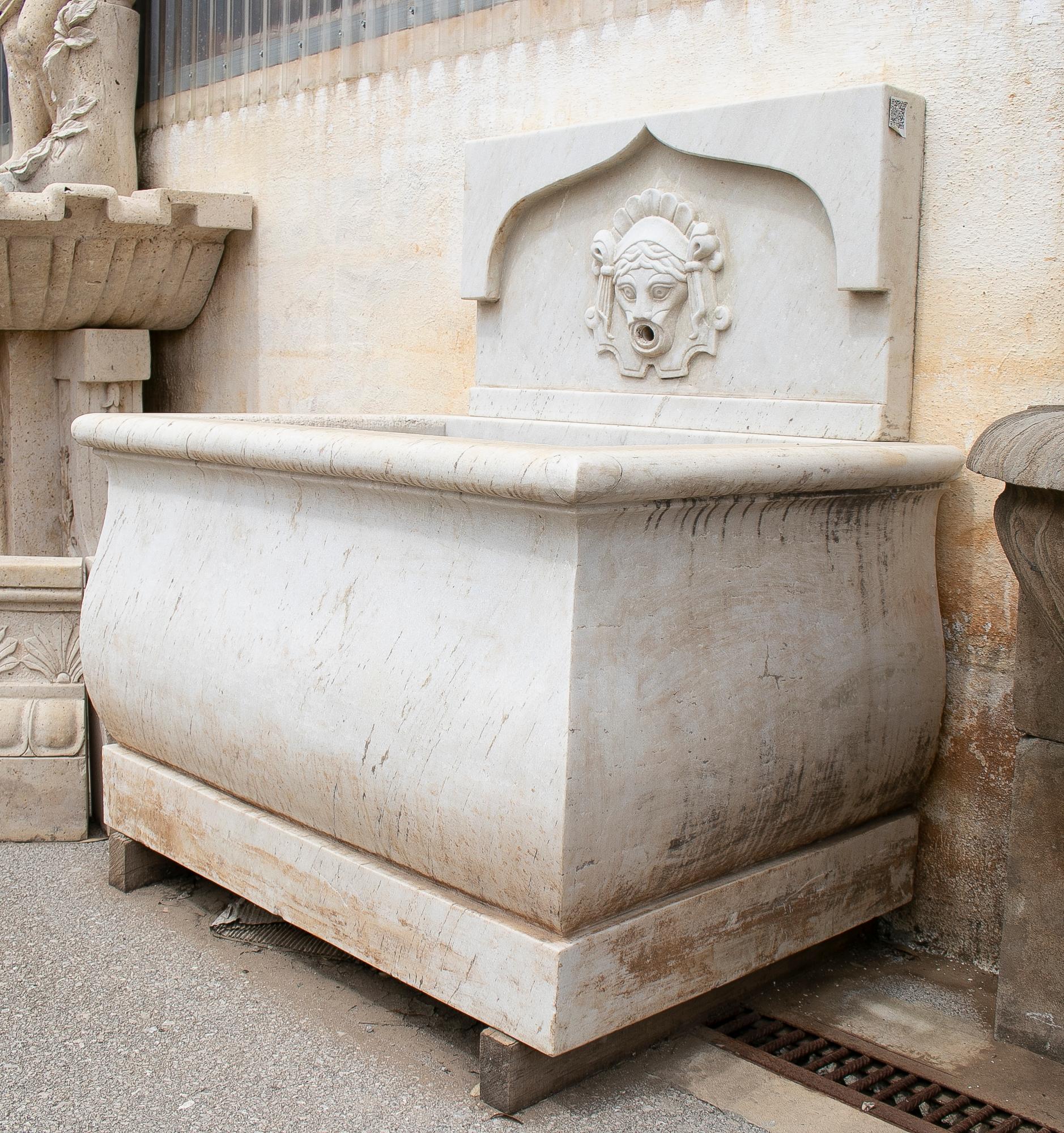 1990s hand carved aged white marble fountain with head sculpture spout.