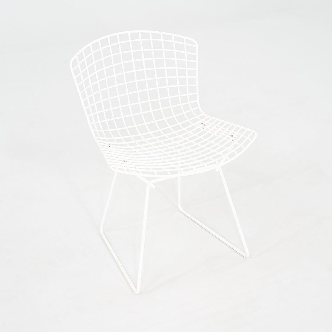This is a Wire Dining Side Chair designed by Harry Bertoia for Knoll, originally introduced in 1952. This particular example was produced in the 1990s and features a welded steel wire frame in a white powder-coated finish.

The chair measures 19.75