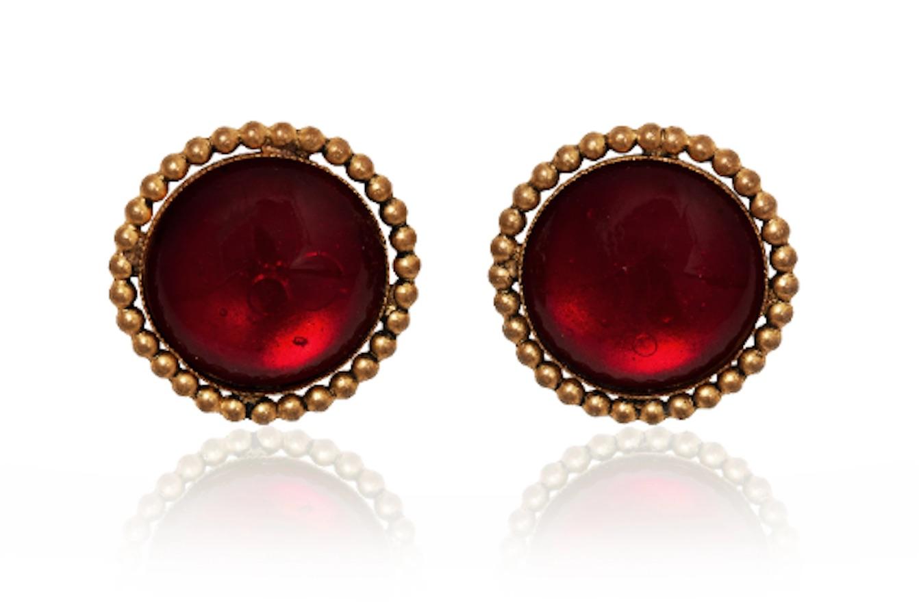 These late 1980s to early 1990s haute couture earrings are entirely handmade from a deep red poured glass (gripoix) set into a beaded circular flat mount of gilt metal.  They are a clip on attachment.  My client was a former model for Harrods and