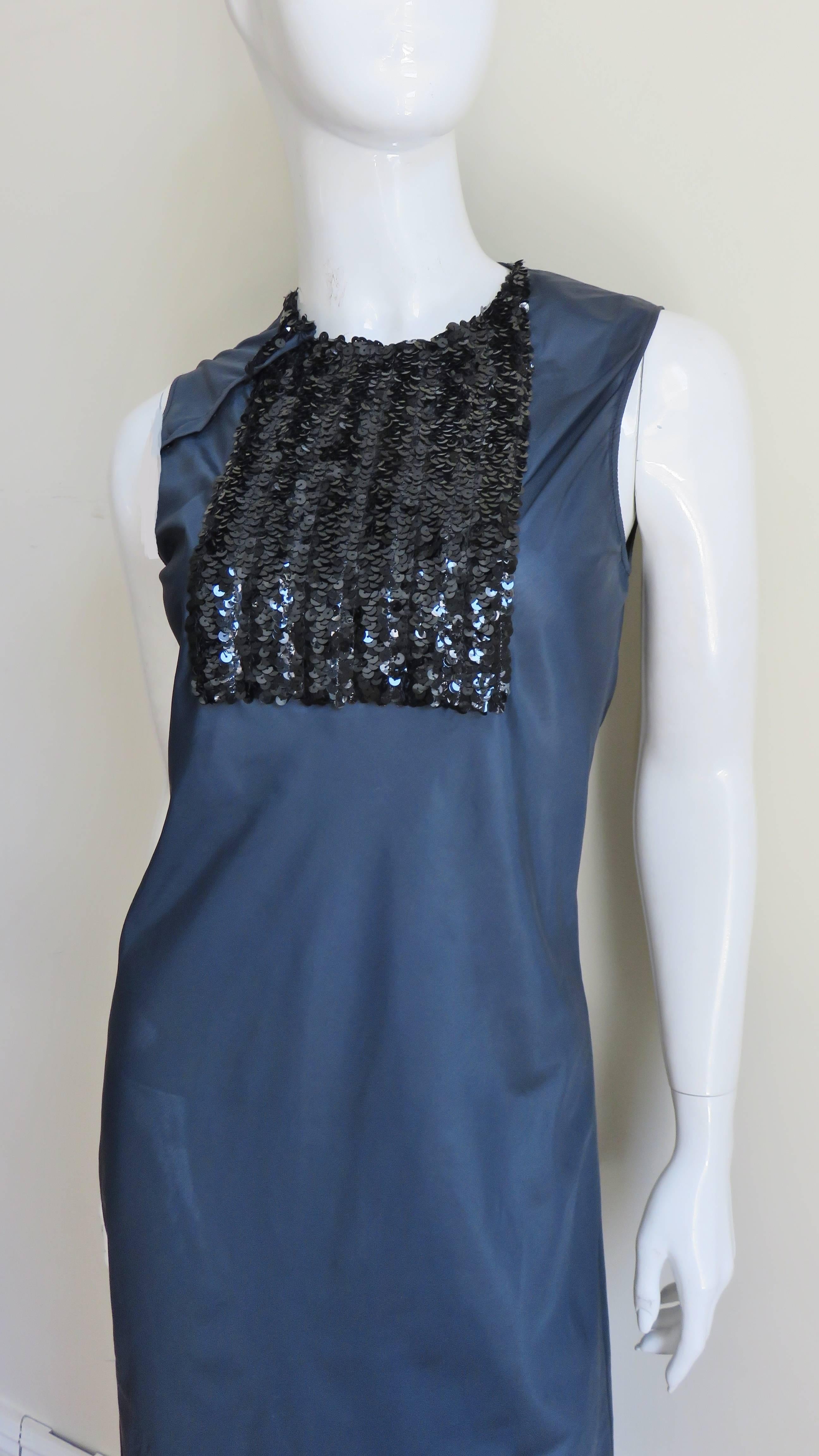 A great navy blue dress by Helmut Lang.  It is a simple crew neck sheath with a square black sequin covered center front panel from neckline to bust.  It is unlined and has snaps closurebat the shoulder seam.
Fits size Small.

Bust  34