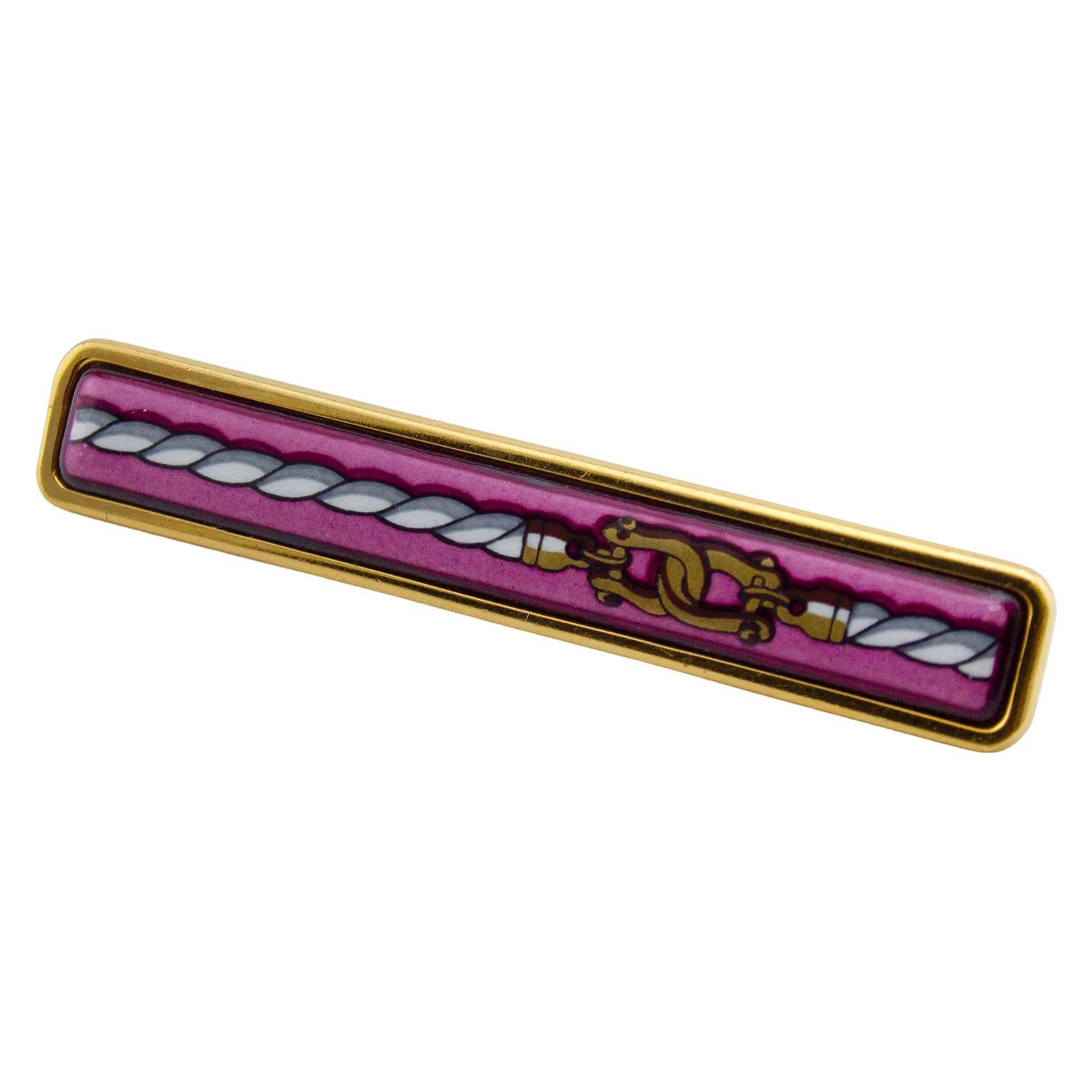 Chic spilla Hermes in oro e smalto rosa della fine degli anni '90. In ottime condizioni con scatola originale.
Può essere indossato sul bavero o attraverso un classico foulard di seta Hermes per fissarlo al collo. Lunghezza 2,25