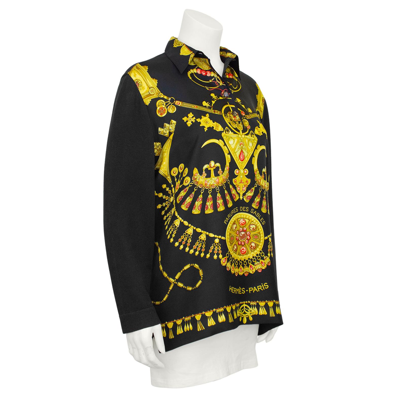 A striking 1990s Hermes mix between a classic shirt and a cardigan. Contrasting black, gold and coral silk printed body featuring the Parures des Sables pattern that was first issued in 1994. The sleeves and back are a fine knit crafted from a blend