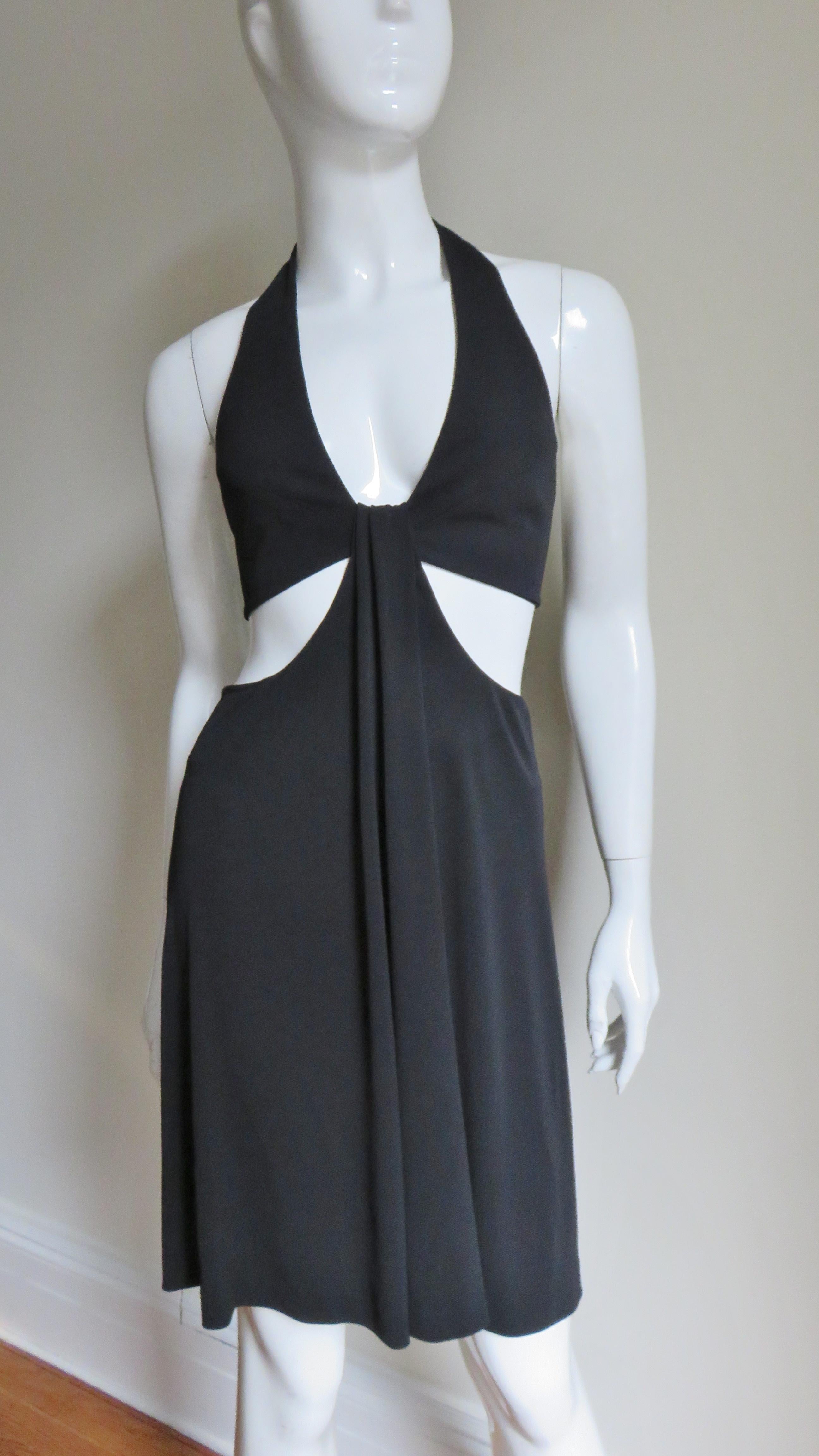 A gorgeous black jersey dress by Herve Leger. Always a master of enhancing the female form this dress is no exception.  It is a halter with a plunging neckline and an exposed waist back and sides.  The back of the dress is bare to just below the