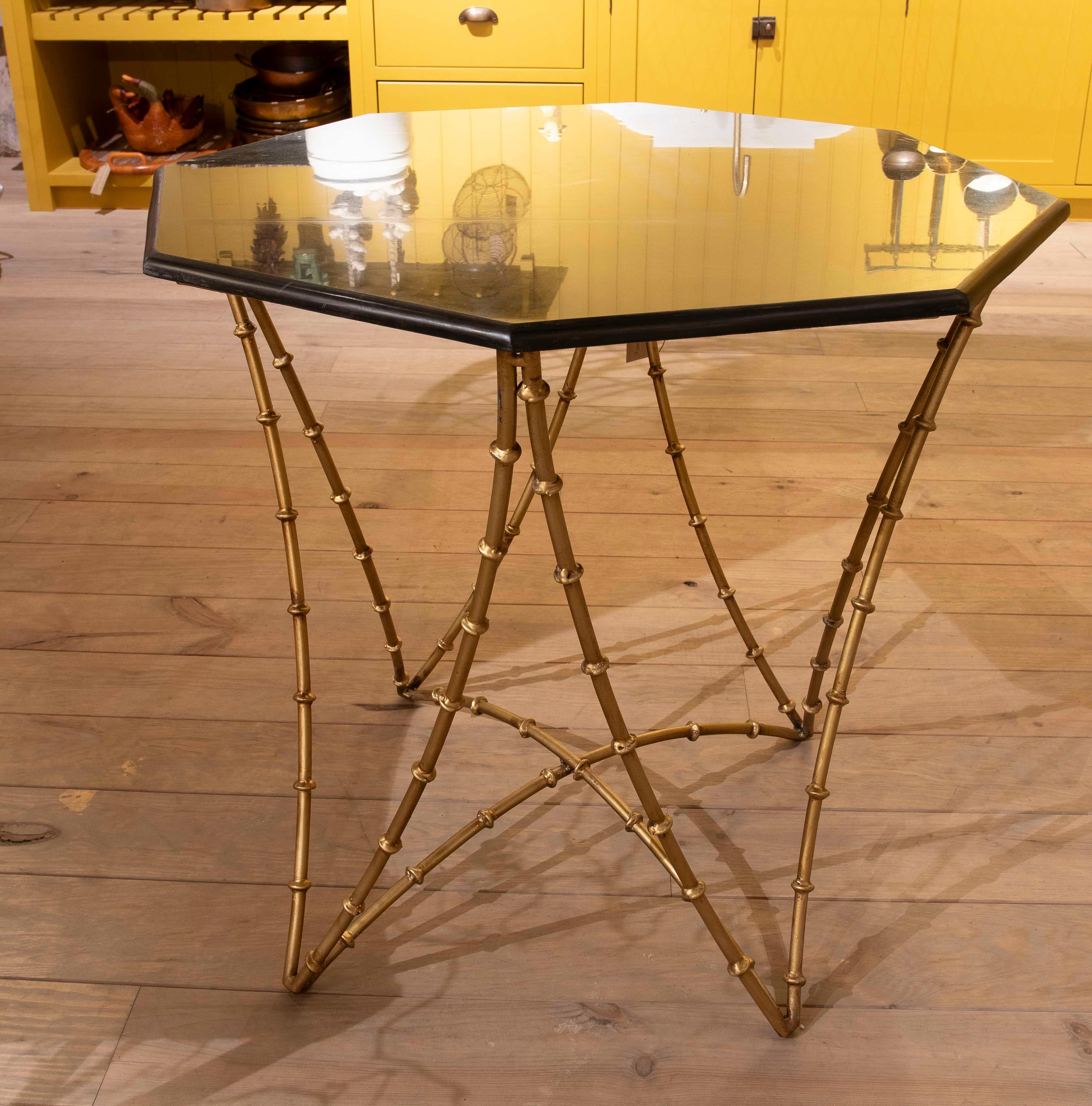 Elegant hexagonal side table, combining a sophisticated gold-painted iron base with a black marble top, creating a piece of great presence and timeless style.

The base structure is designed with thin bamboo-shaped iron rods, providing an exotic and
