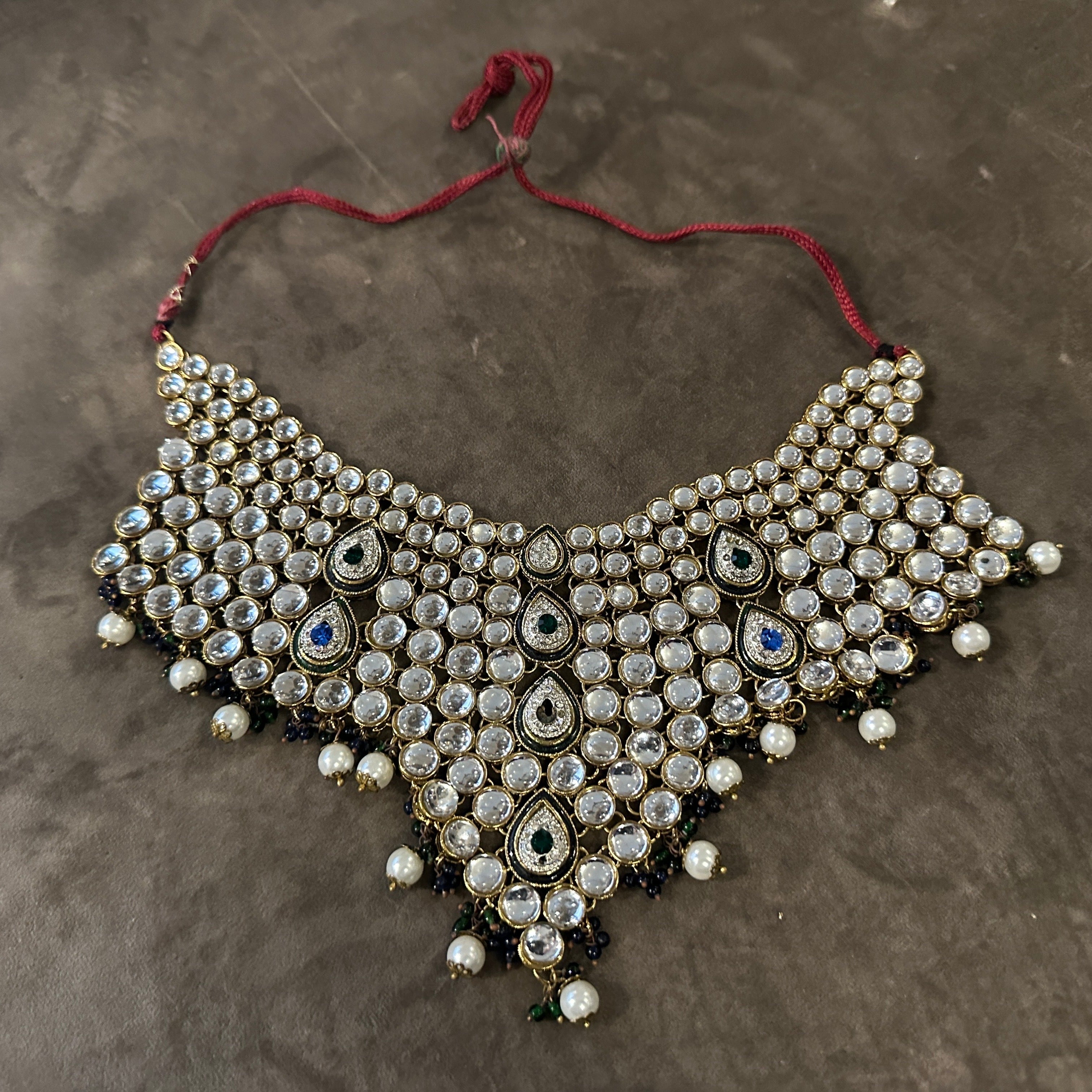 Squisita collana indiana anni '90 con pettorina in stile Kundan
Questa collana vintage mozzafiato con pettorina è un capolavoro di artigianato indiano di alta qualità degli anni Novanta. Questo pezzo a più fili mette in mostra il design opulento e