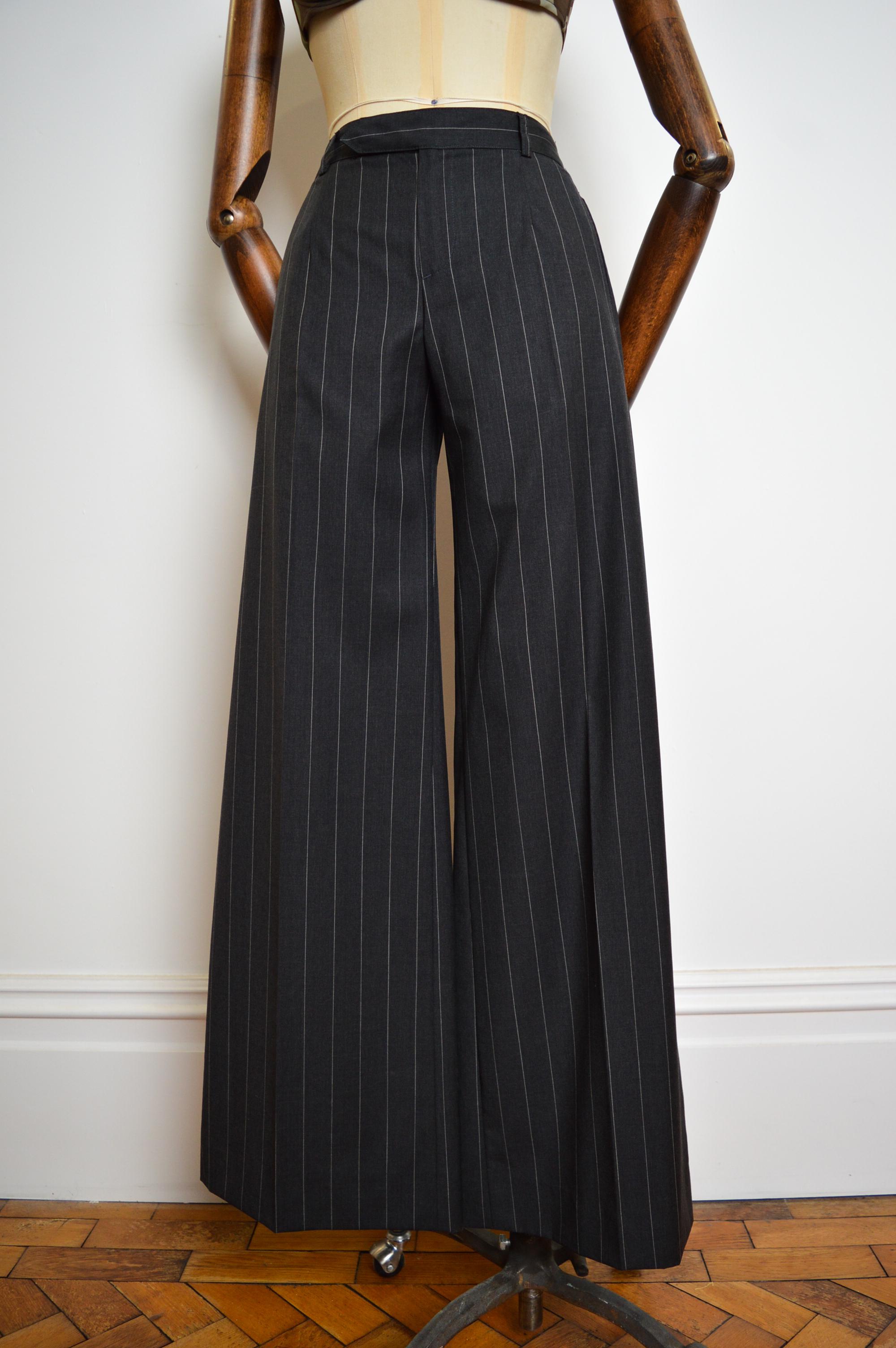 Sublime Vintage 1990's 'Jean Paul Gaultier' wide legged Tailored pin-striped pants in Charcoal grey. Timeless !

MADE IN ITALY !

100% Virgin Wool.

Features : High waisted, Zip hook closure, signature Gaultier loop detail at the back, Belt loops, 4