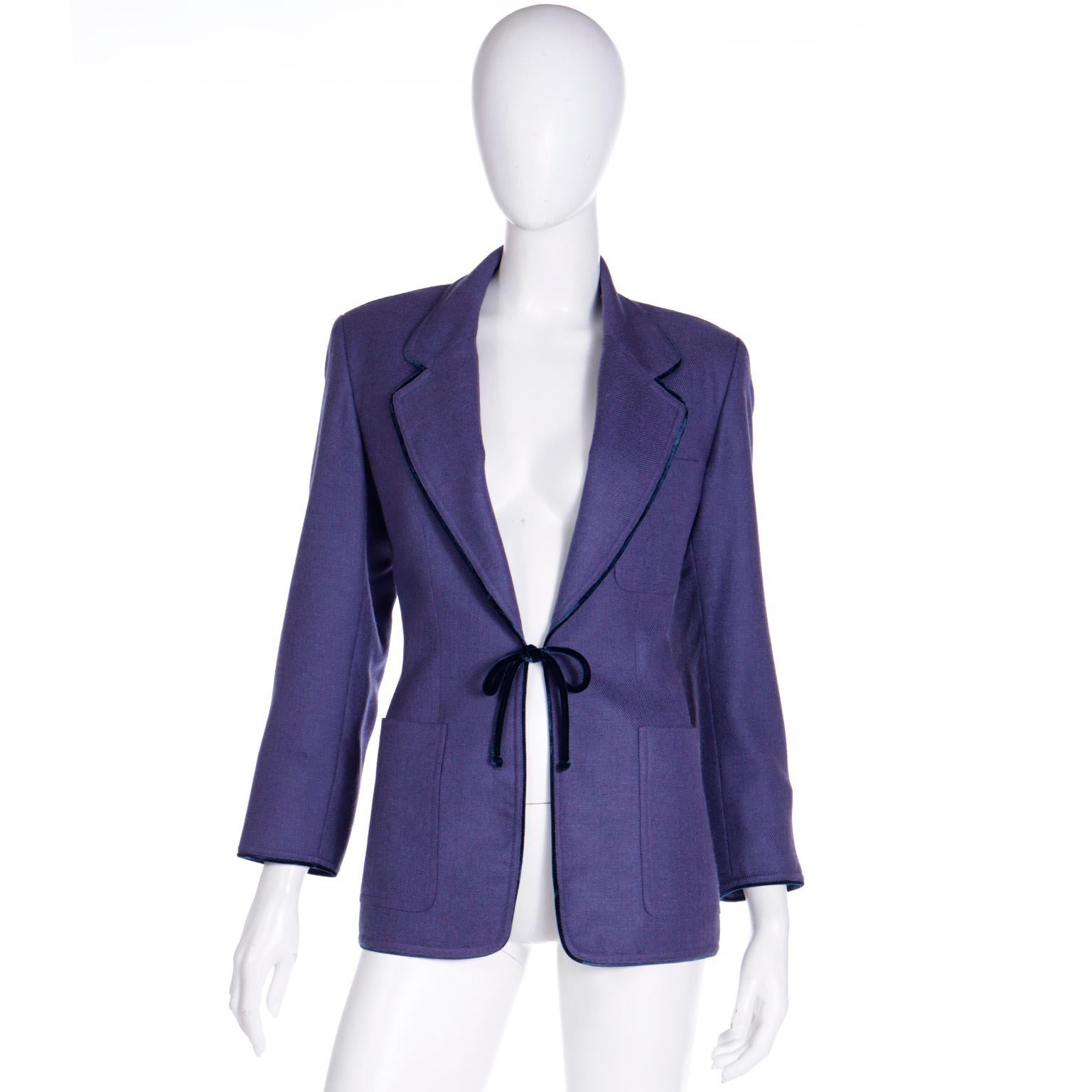 This vintage 1990's Isaac Mizrahi blazer style jacket is in a luxe purple wool medium weight fabric and it has a darker velvet piping edging on the lapels and the cuffs and a velvet tie closure at the waist. The jacket is fully lined and it has 3
