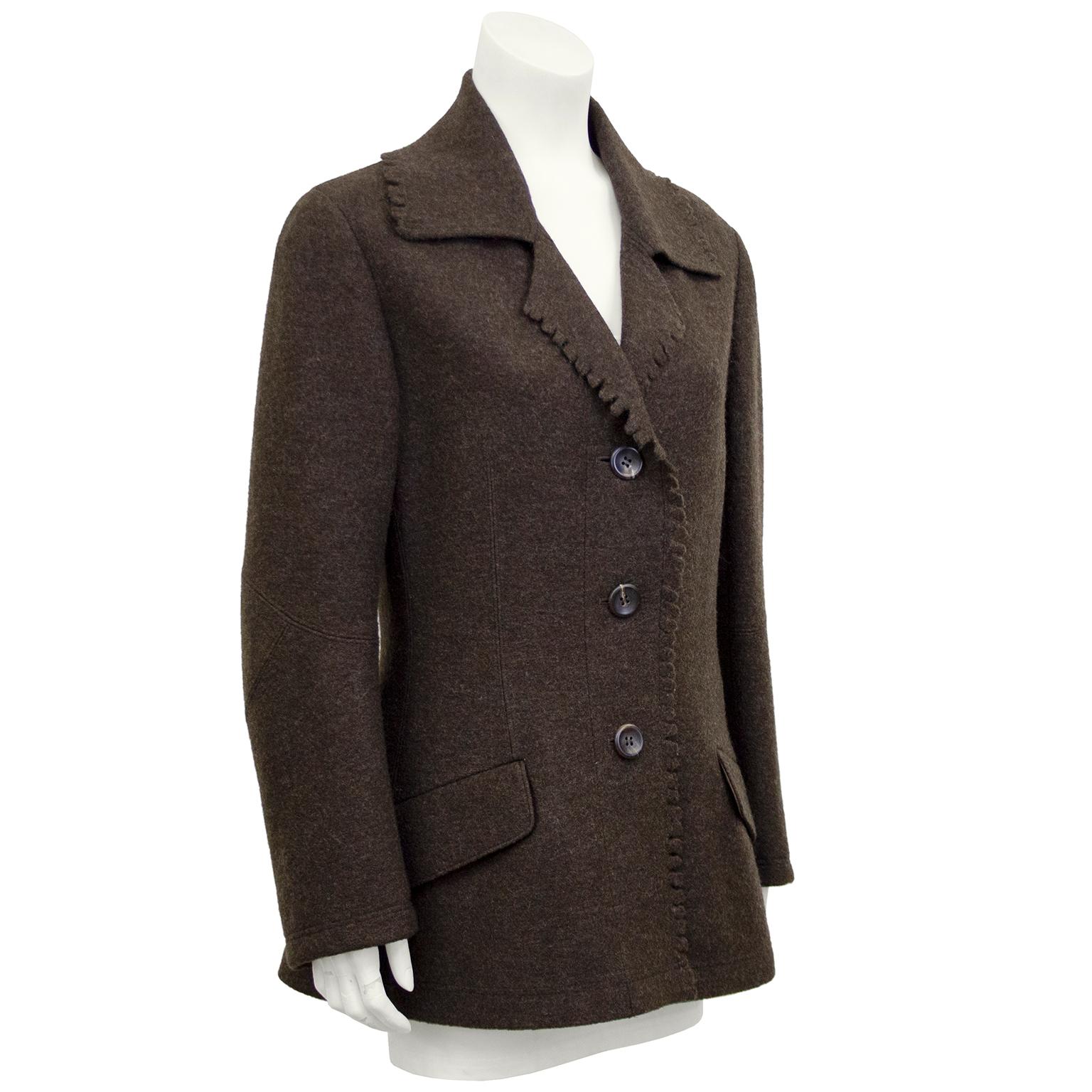 Issey Miyake coat from the 1990s. Brown felted wool with hand cut scalloped trim. Matching large brown plastic buttons. Oversize lapel. Stunning tailoring and draping with beautiful seams that slightly accentuate the waist. Slanted flap pockets.