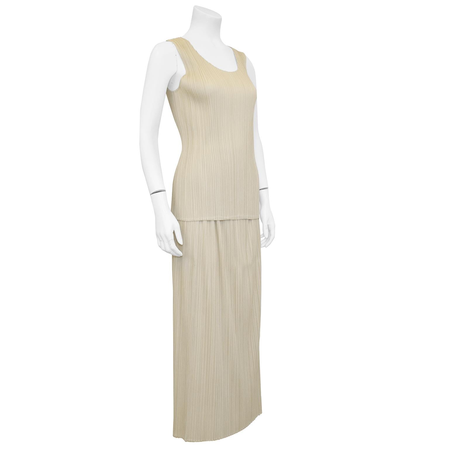 Issey Miyake cream ensemble from the 1990s. Sleeveless scoop neck top and midi length pencil skirt in the classic Issey Miyake micro pleating. Excellent vintage condition. Size small. Made in Japan. Great for travelling as these pieces do not