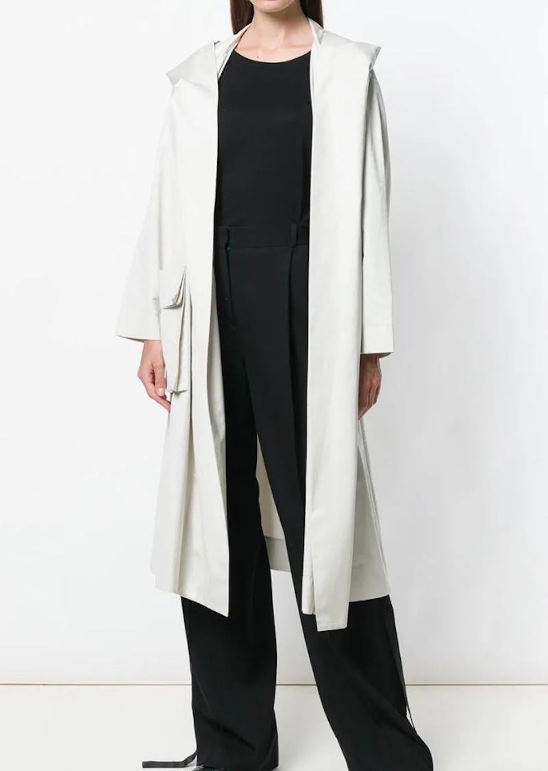 circa 1990s

Off-white cotton blend Hooded trench coat from Issey Miyake featuring a hood, a concealed front fastening, long sleeves, front flap pockets and a mid-length. 

Polyester 57%, Cotton 23%, Nylon 20%

size M