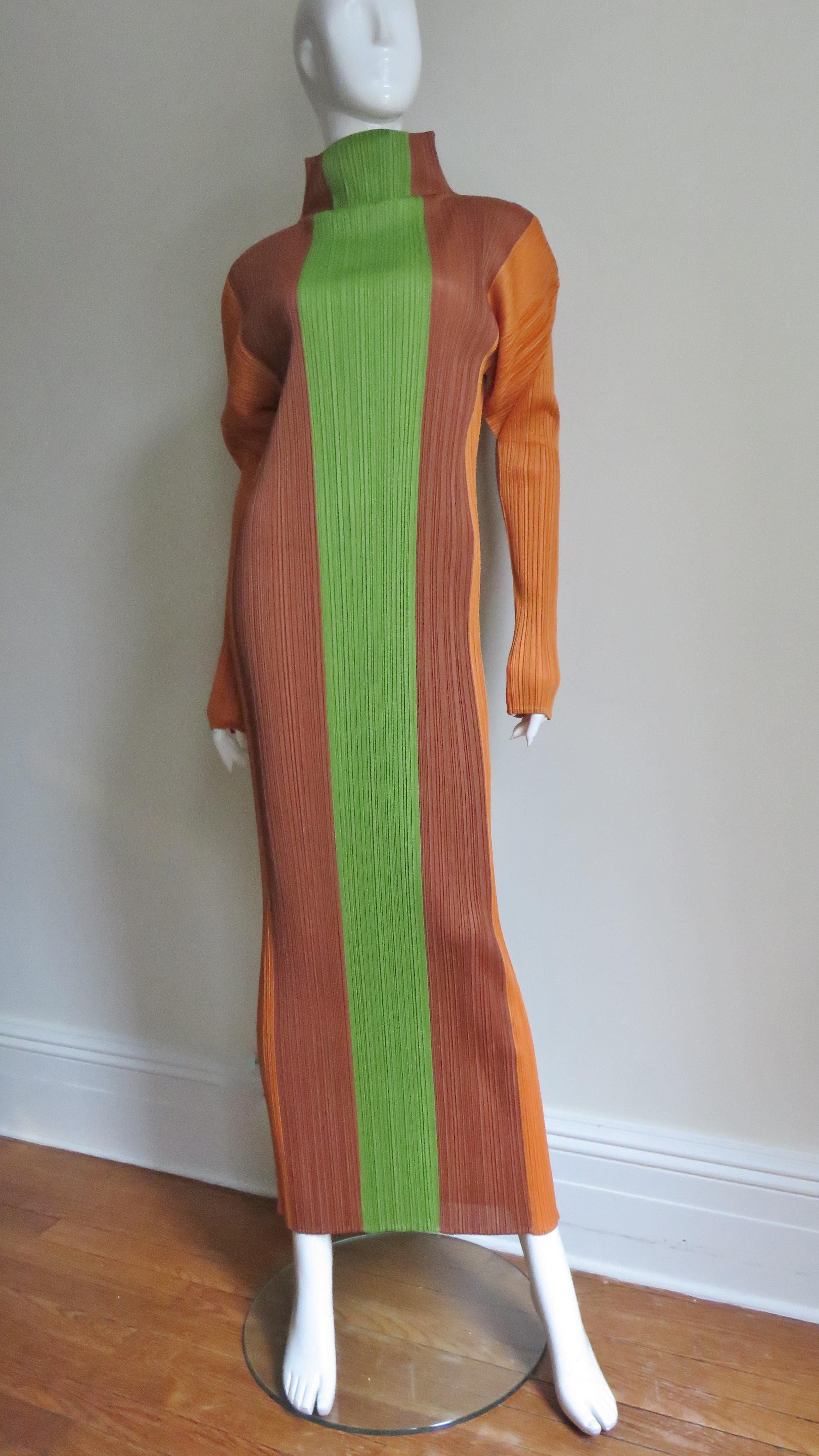 A beautiful color block signature micro pleated maxi dress from Issey Miyake in vertical panels of green, chocolate brown and orange. It has a stand up collar, long sleeves and slips on over the head. The fabric pleating conforms to the