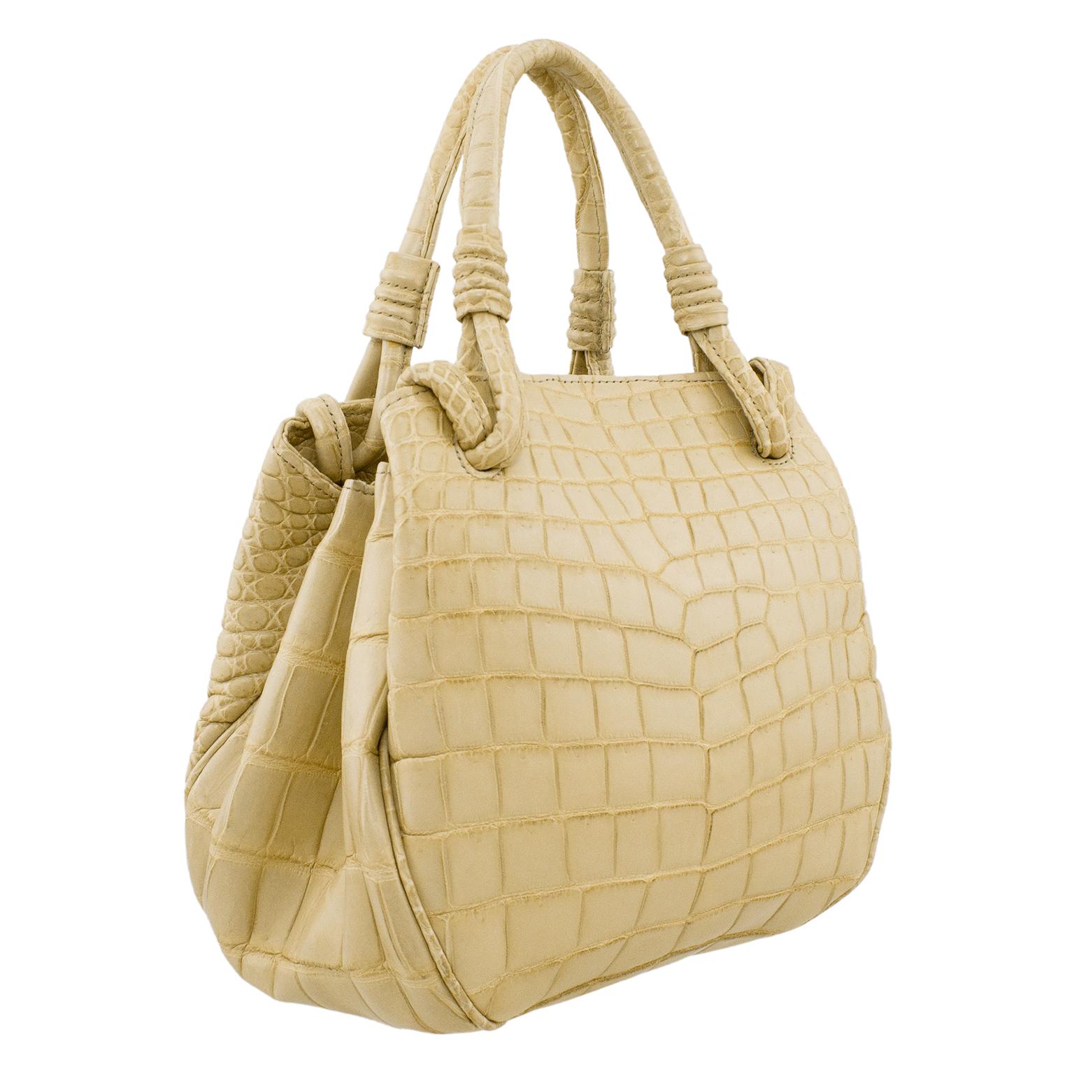 Just stunning matte beige croc effect handbag made in Italy for high end Canadian retailer Davids in the 1990's. Great shape and size, slightly rounded with top handles. This bag looks like it is on the smaller size, but it opens accordion style and